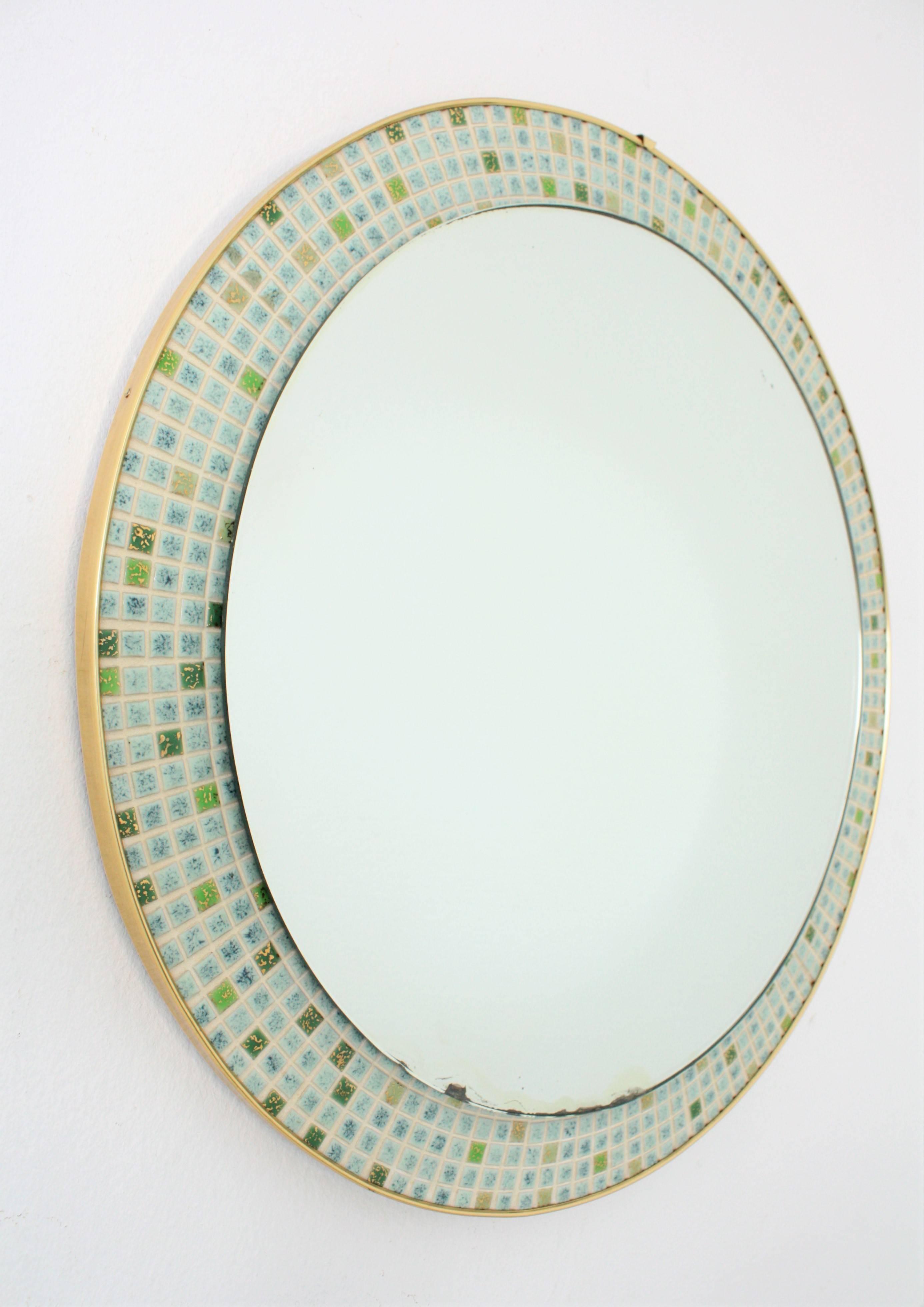 Mid-Century Modern Ceramic Mosaic Round Mirror. Spain, 1960s.
This eye-catching mirror has a frame made of hundred of small ceramic tiles in pastel colors in shades of blue / green and gold leaf accents.
It will be a nice addition to a bathroom or