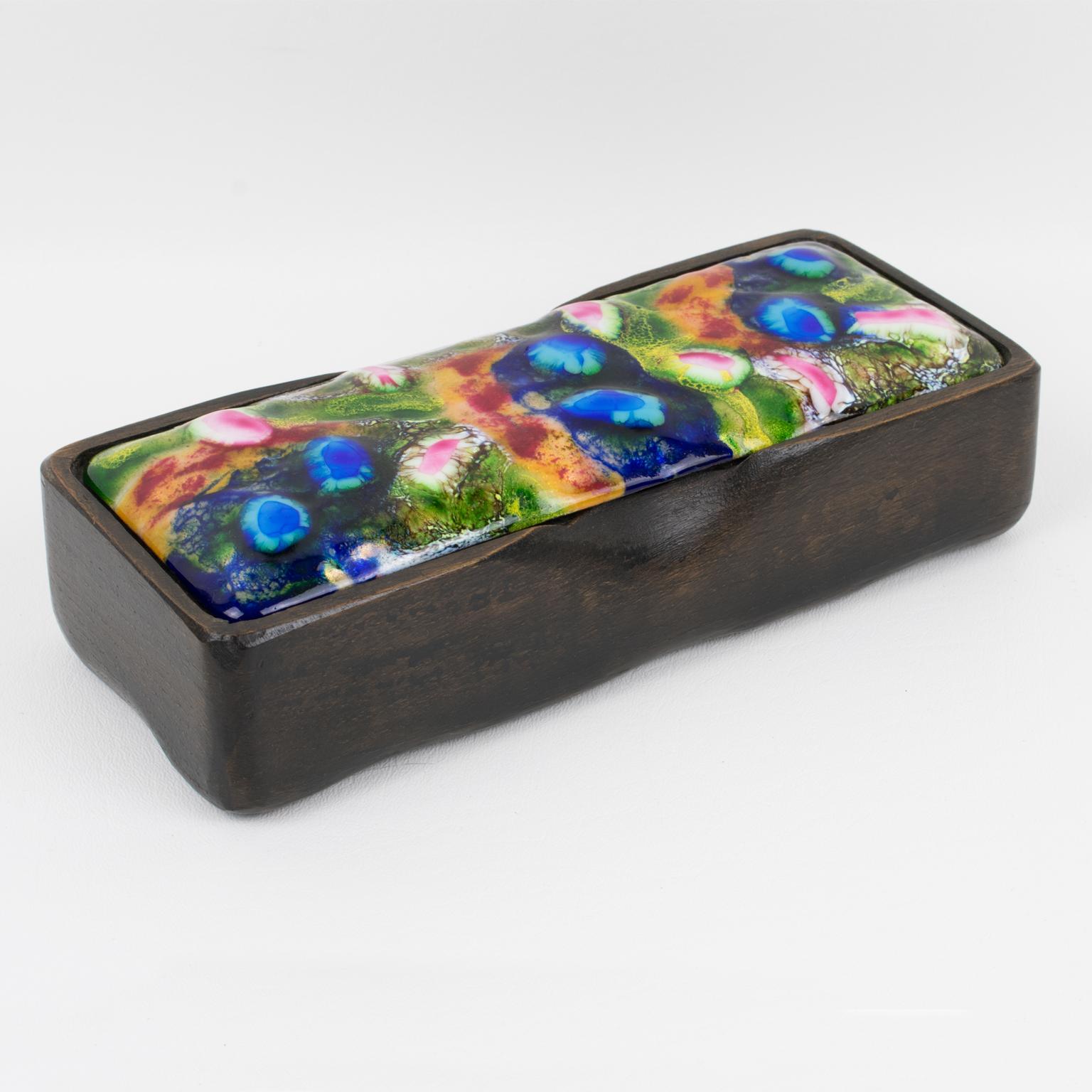 This beautiful Spanish Mid-Century-Modern decorative lidded box was hand-crafted by J. Capo Esmaltes in the 1960s. The rectangular shape boasts a carved wood container base with a lovely organic flair. The enamel-on-copper lid has a stunning