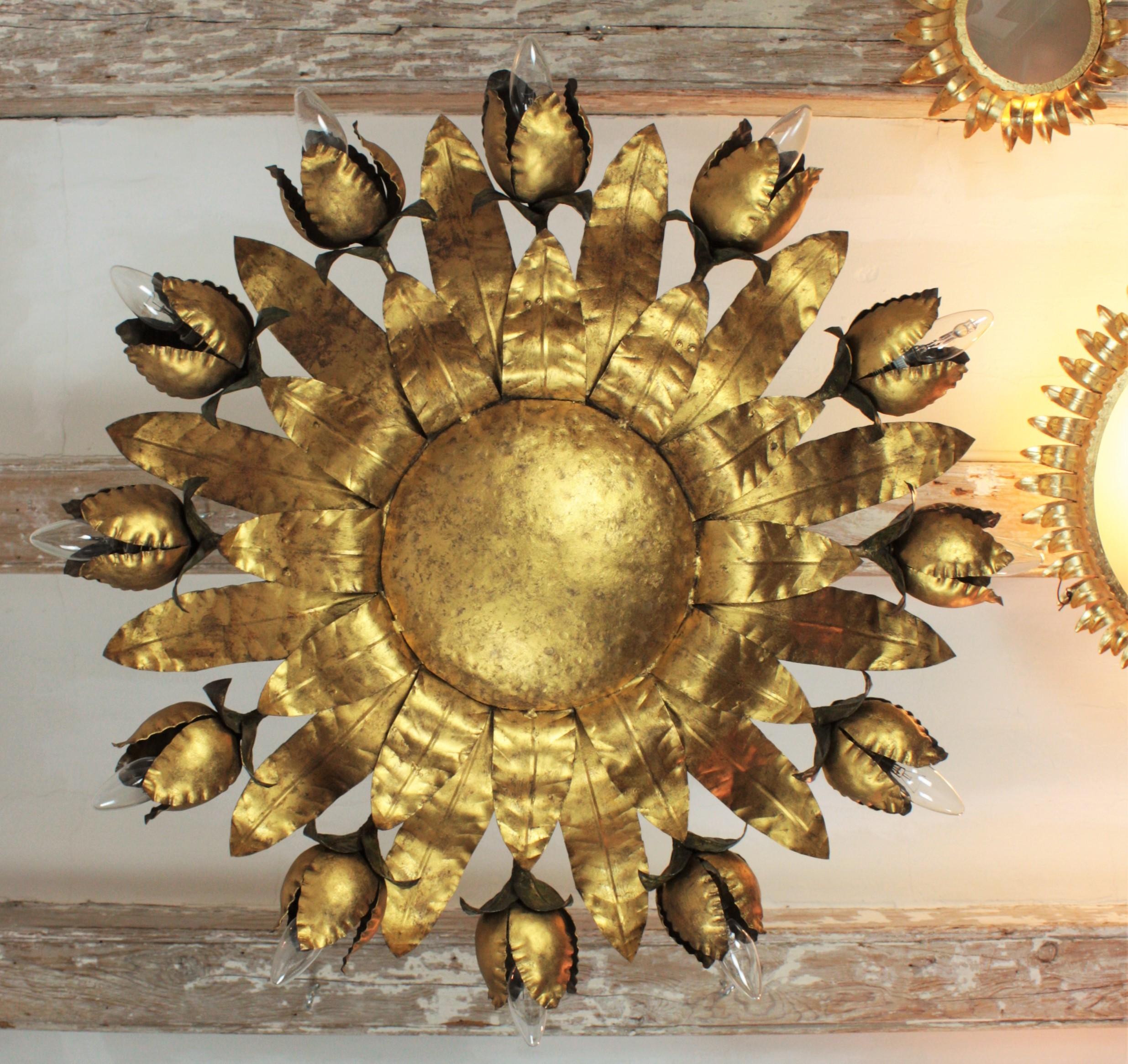 Monumental hand-hammered gold leaf gilt iron floral chandelier or ceiling light fixture with 12 flower bulb holders. An interesting piece due to its size, and its highly decorative effect with handcrafted iron flowers distributed around a central
