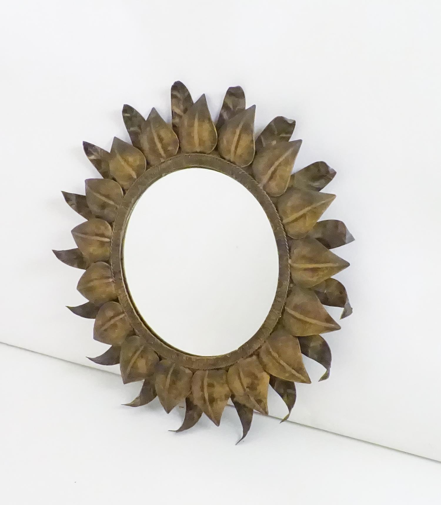 Sonnenförmiger Spiegel aus Schmiedeeisen, 1960er Jahre.
Zwei Reihen von Blättern, Pflanzendekoration in Form von Sonnenstrahlen, die ihm Tiefe verleihen.
Spanischer Ursprung, hergestellt in einer alten Schmiede in Cehegín, Murcia.
Der Mond ist in