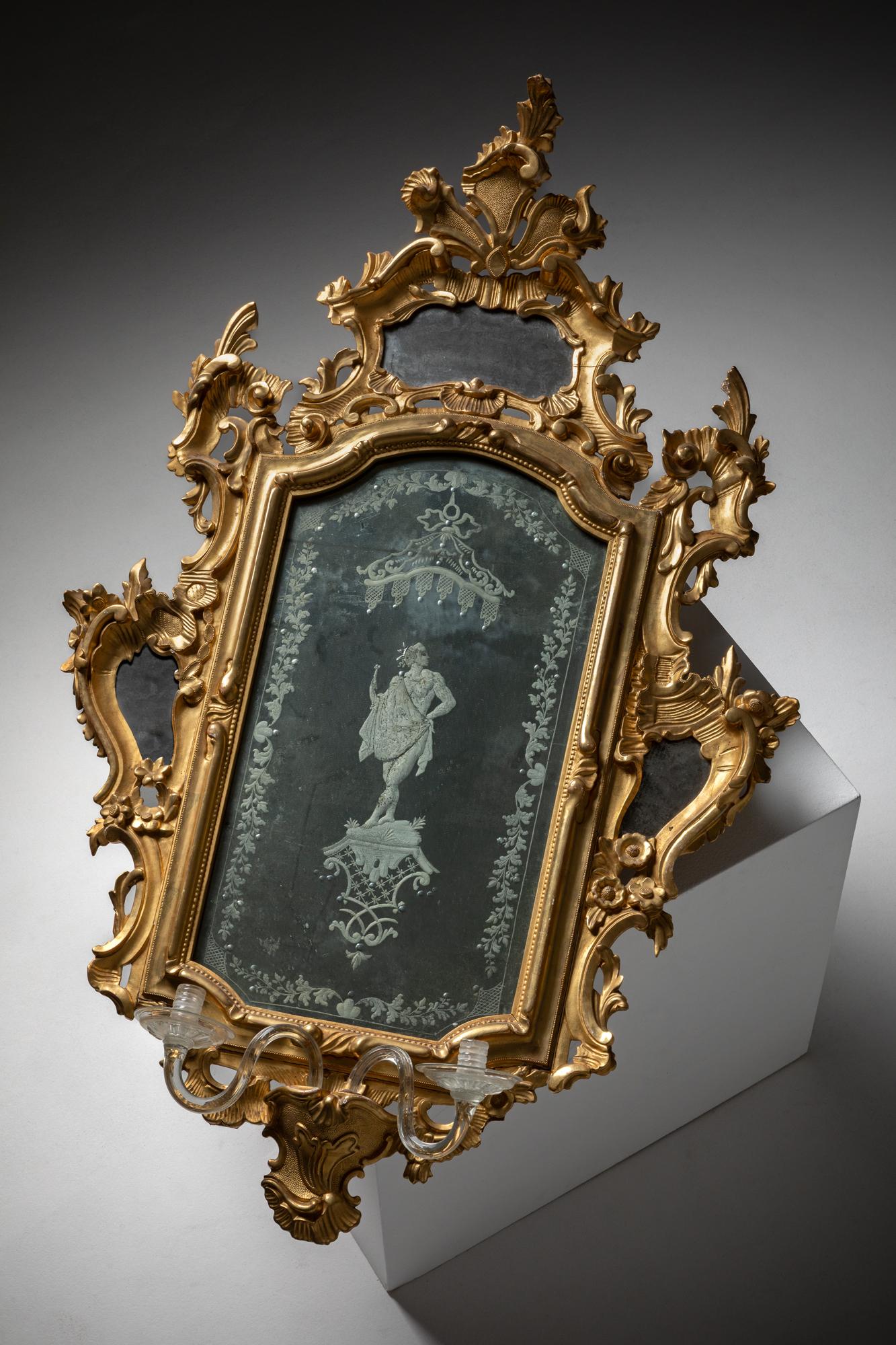 Il s'agit d'un magnifique miroir Charles III, fabriqué en Espagne au cours du XVIIIe siècle. Le miroir est encadré de bois finement sculpté et doré, illustrant le style rococo élaboré en vogue sous le règne du roi Charles III. Les sculptures