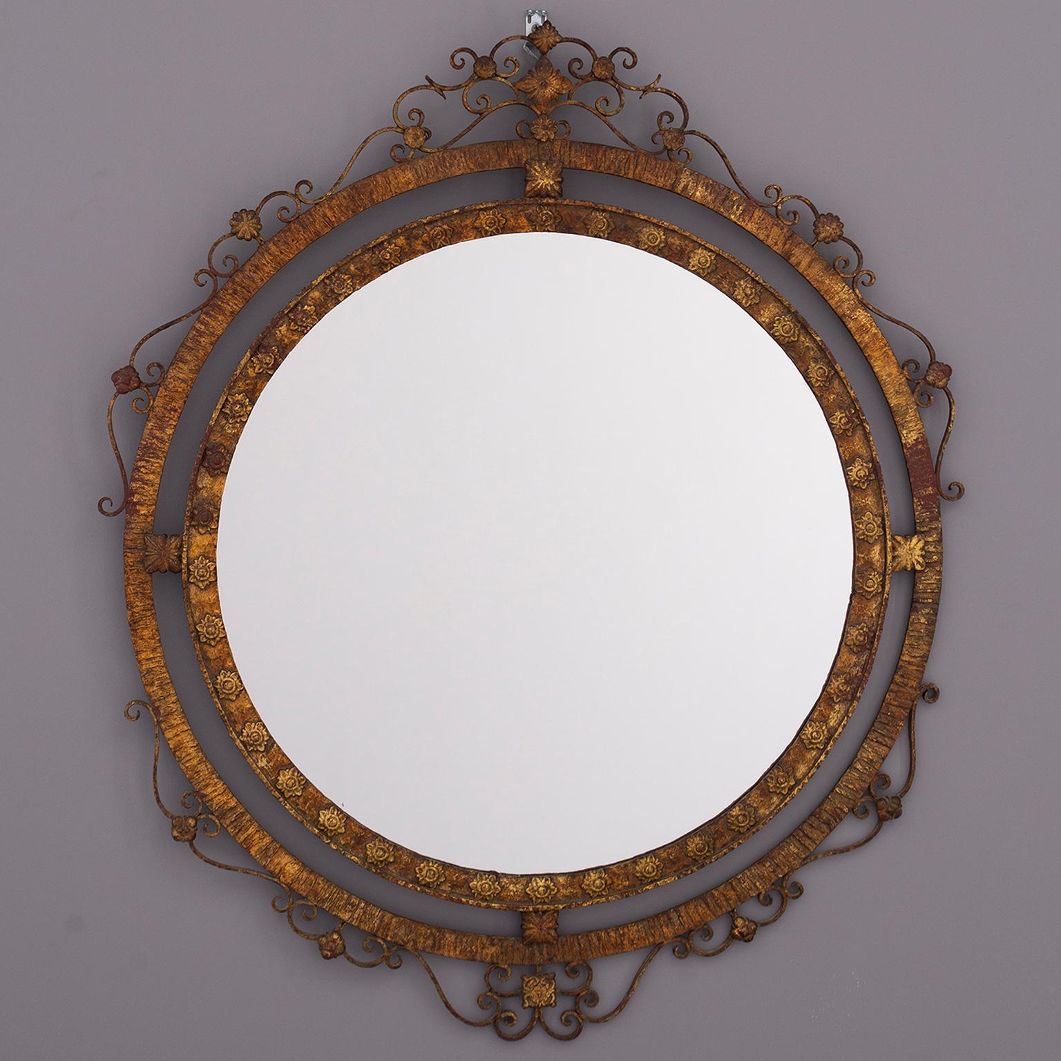 Round Spanish mirror has a gilded iron frame with a decorative crest and double, open work edge, circa 1930s. Unknown maker.