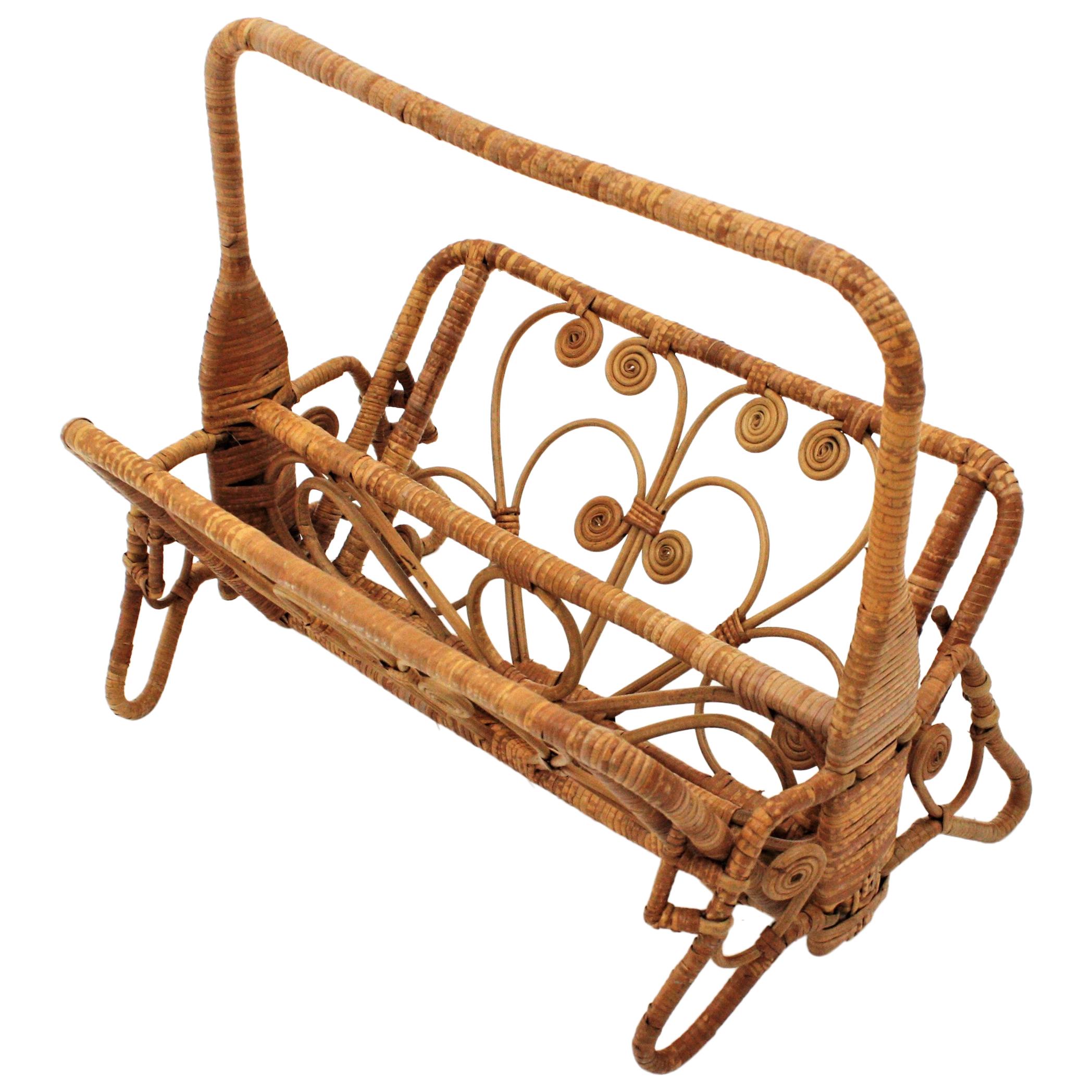Handcrafted wicker / rattan folding magazine rack with beautiful artistic filigree work. Spain, 1960s.
This magazine / newspapers rack features a wicker structure with a handle and two foldable panels standing on four small legs. Beautifully