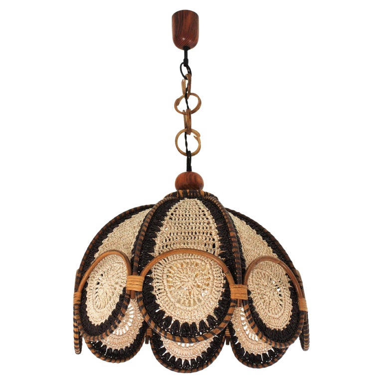 A funny hand knotted macramé suspension lamp in beige and brown color with rattan circles accenting the bottom. Spain, 1960s-1970s.
This handcrafted chandelier features a shade made of hand knotted macramé acrylic cord. The top of the shade is