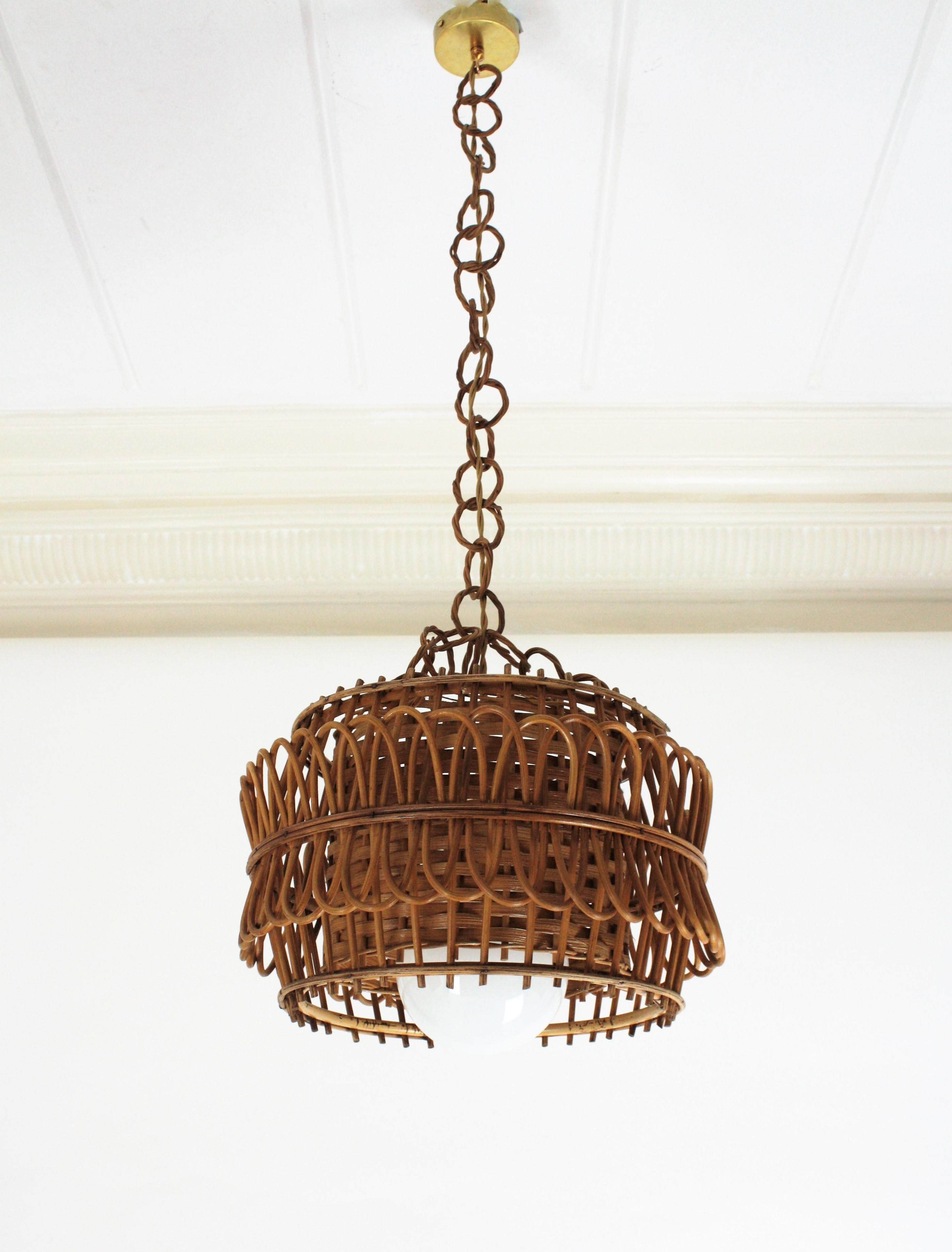 A cool handcrafted Mediterranean Mid-Century Modern rattan and wicker pendant or suspension lamp, Spain, 1950s-1960s.
This ceiling lamp features a woven wicker shade at the interior part surrounded by a beautiful intricate of rattan canes at the