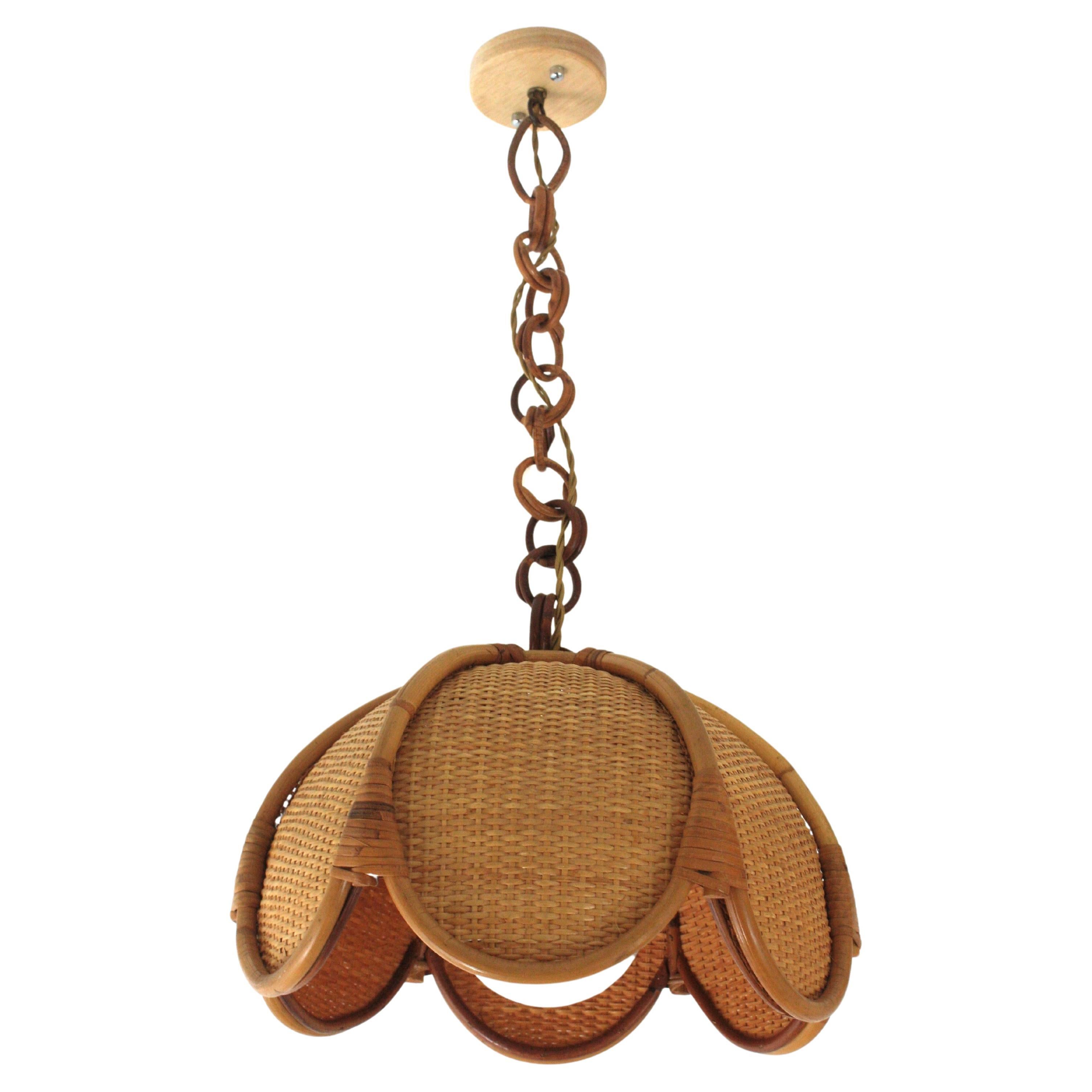 Elegante lampada a sospensione artigianale in bambù e rattan intrecciato / vimini a forma di fiore o di palma. Spagna, anni '60.
Questa bellissima lampada a sospensione presenta una grande struttura di paralume in bambù a forma di palma con barre