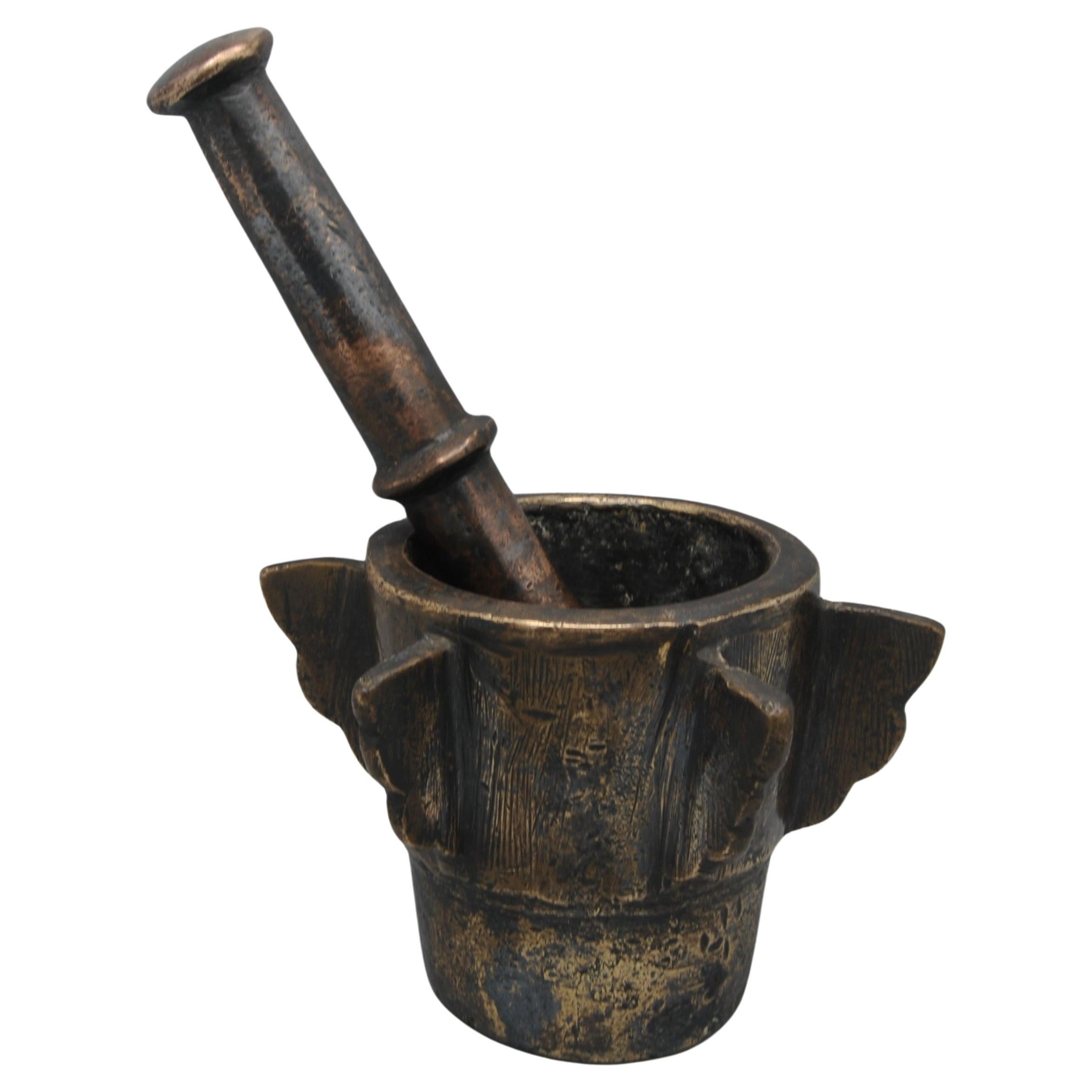 Spanish - Moorish Gothic bronze mortar and pestle with ribs, most likely from Andalusia.
Of conical shape, resting on a circular uneven base, the exterior decorated with a series of wing-shaped protruding vertical ribs and engraved with a wavy