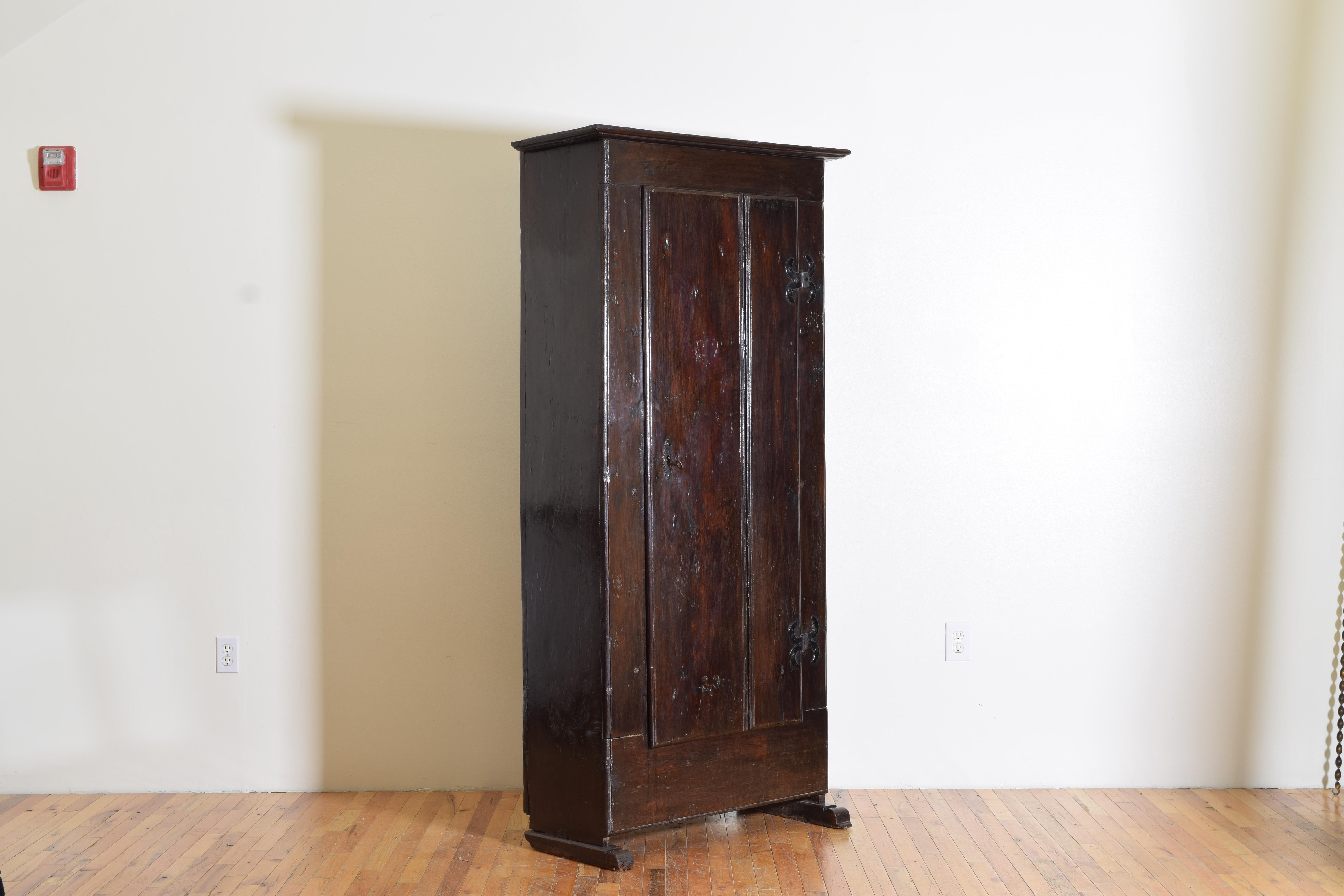 From Northern Spain, constructed of solid oak, crudely carved one door hinged with decorative as well as functional iron strapping raised on two plinth sleigh-like bases. The Interior has three shelves for storage.