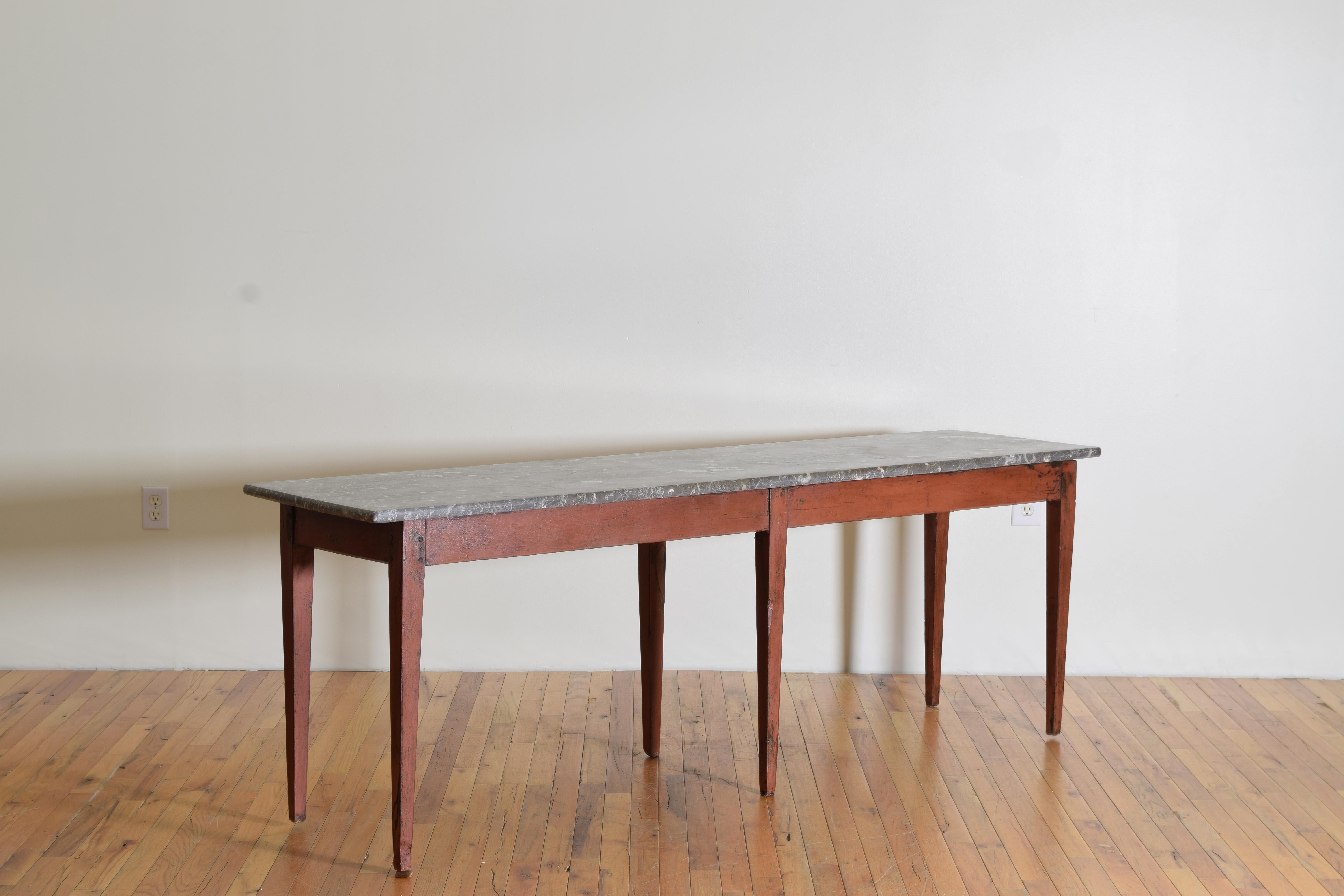 The rectangular marble top resting atop a 6-leg painted base with square tapering neoclassical legs, the light red paint secondary to an early blue painted finish.