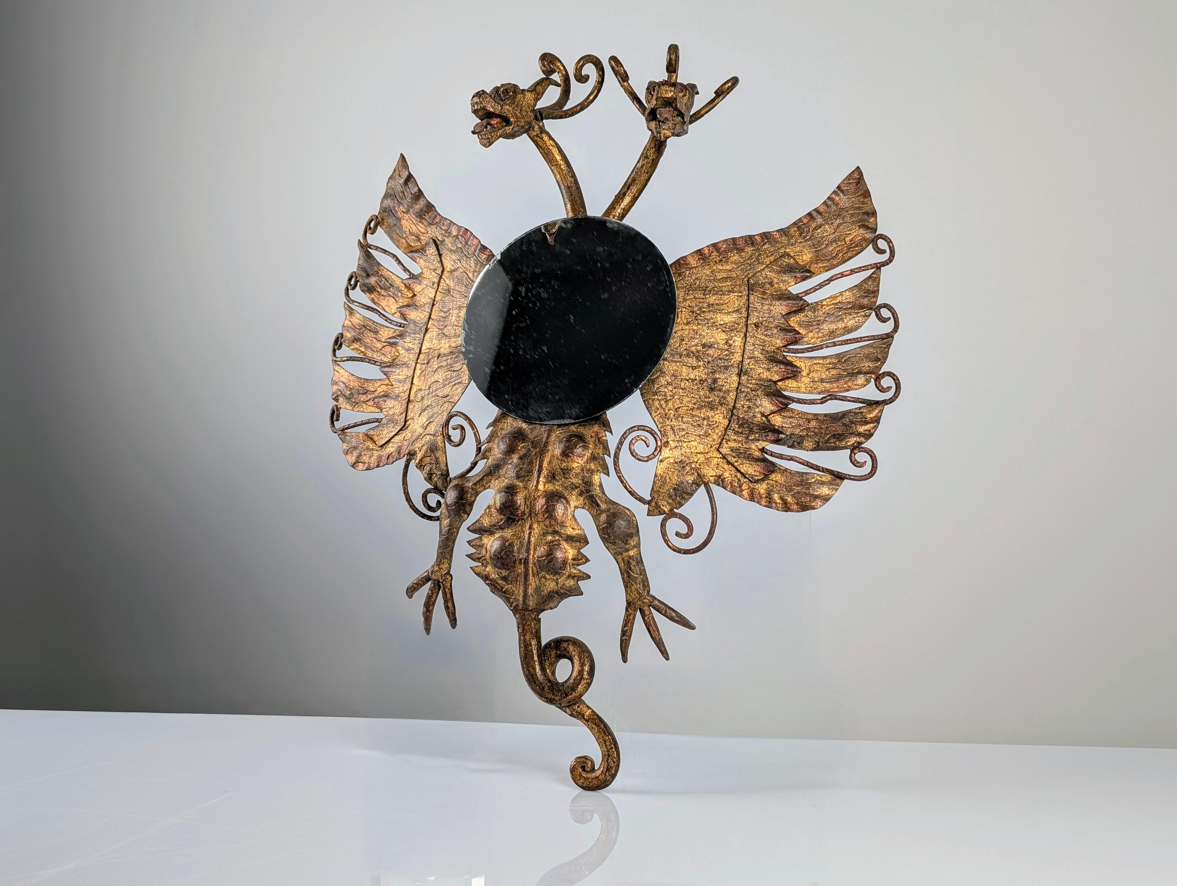Imponente specchio in ferro dorato con uno spettacolare design neogotico spagnolo, caratterizzato da un maestoso drago a due teste. Questo pezzo è un capolavoro di lavorazione artigianale del ferro, con un'elaborata lavorazione del metallo che evoca