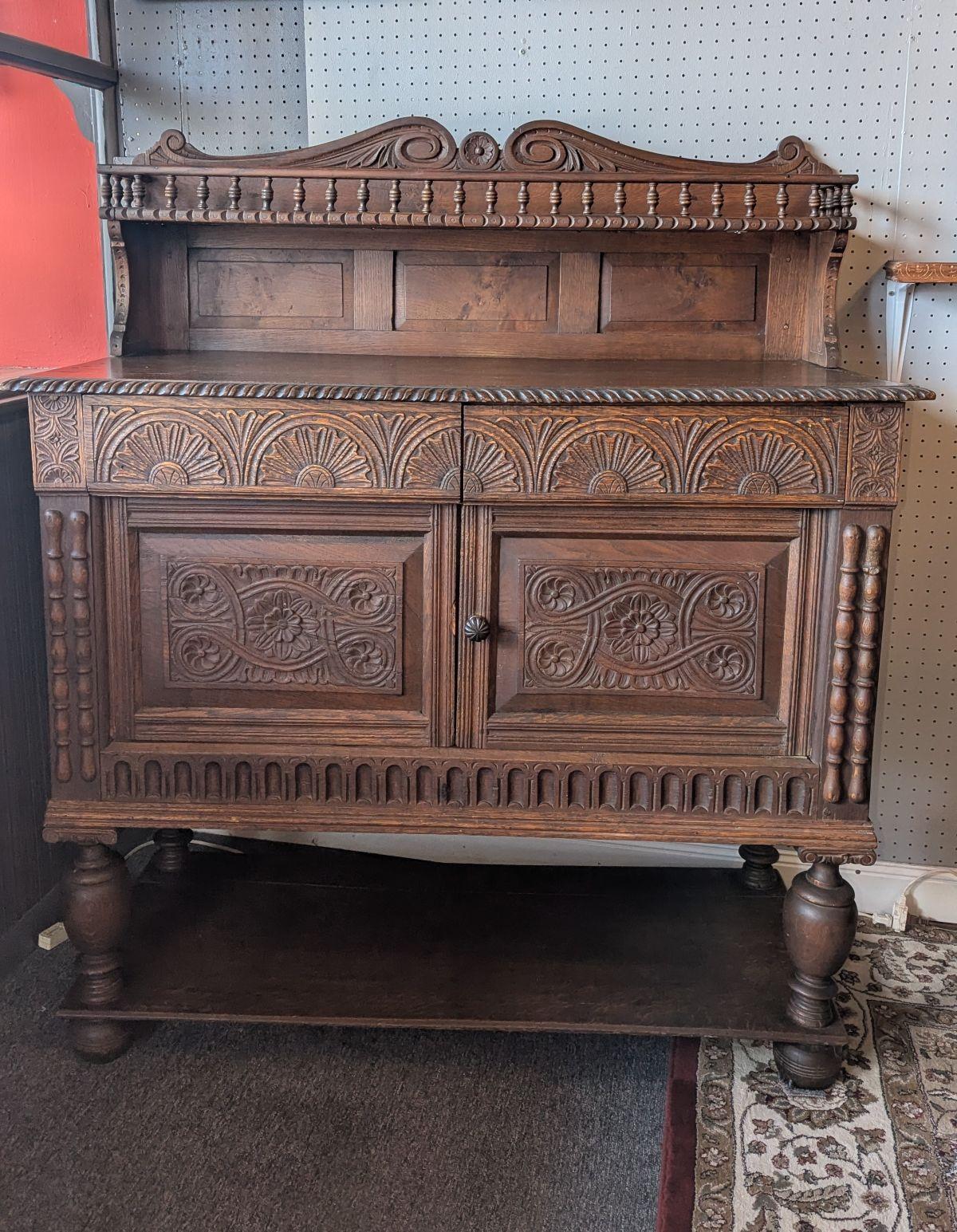 This is a very nice Spanish Server / side cupboard from 1880 with dowel and pin construction in all solid antique oak.  Bun feet under a lower shelf with cupboard supported by four bulbous turned columns, two doors and two drawers that are highly