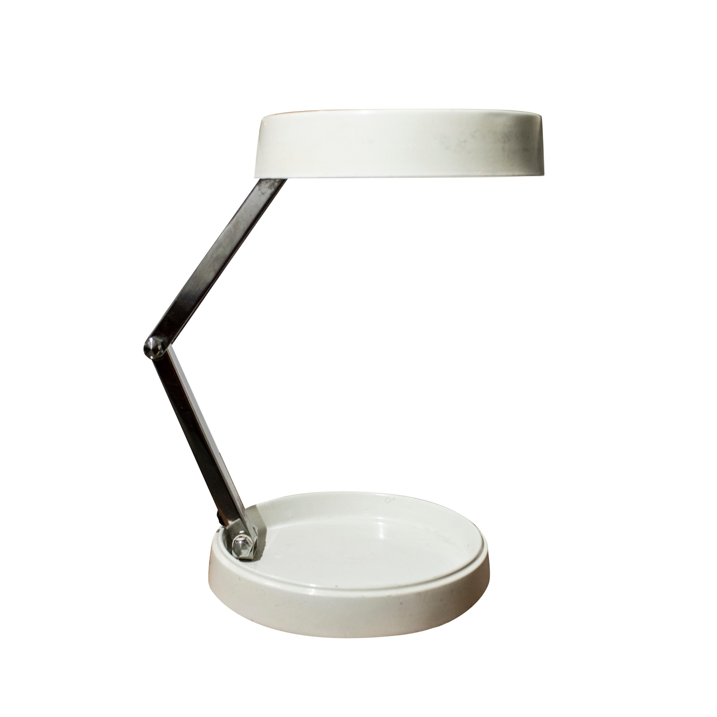 Mid-century modern off-white folding table lamp Designed by Enrique Aparicio and edited by G.E.I., Gabinete de Estudios Industriales. It consists of a round flat metal base and lamp shade with a metal tube structure that can be folded.
Upon folding