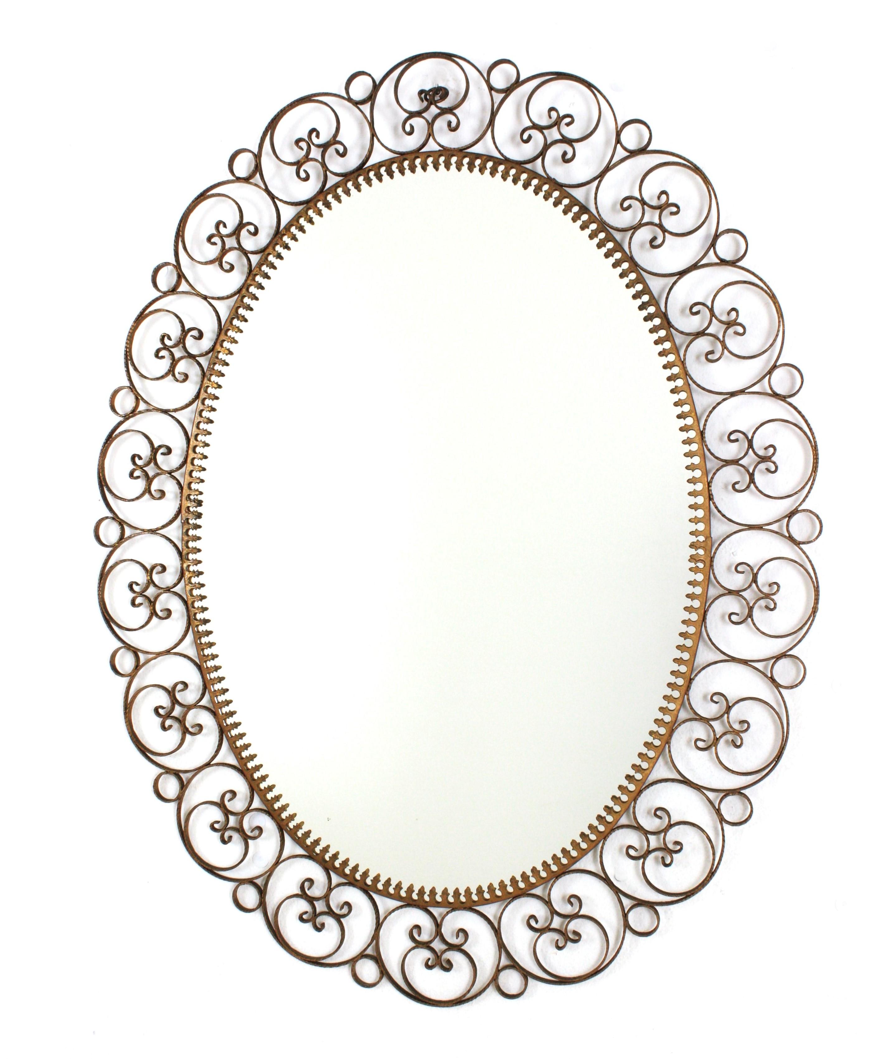 Gilt lron Scrollwork Sunburst Oval Wall Mirror
Mid-Century Modern iron oval wall mirror with filigree scrollwork frame, Spain, 1950s.
This eye-catching sunburst mirror has a nice patina showing its original gilding.
Placed over a vanity in a powder