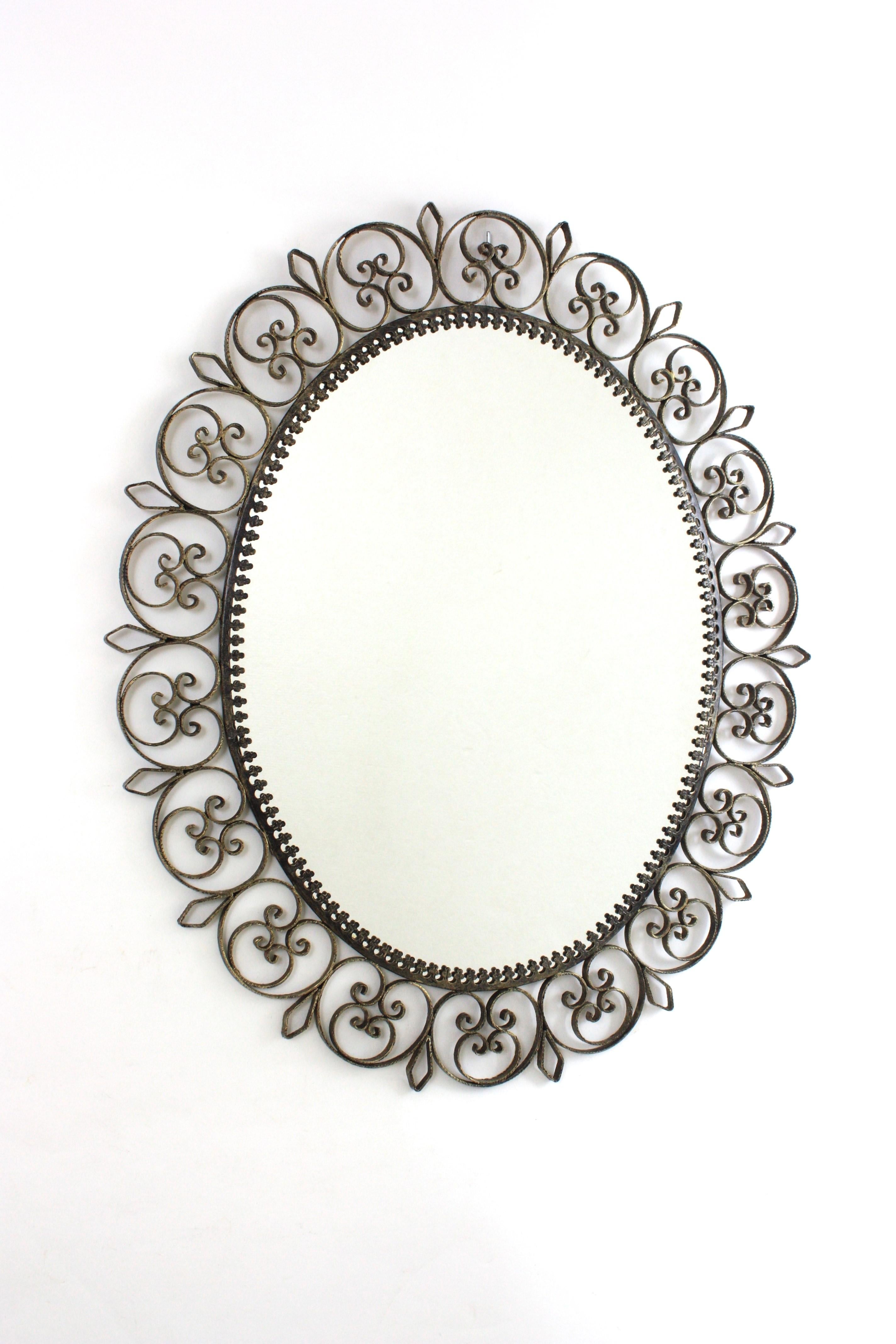 lron Scrollwork Sunburst Oval Wandspiegel
Ovaler Wandspiegel aus Eisen mit filigranem Rahmen aus der Jahrhundertmitte, Spanien, 1950er Jahre.
Dieser auffällige Spiegel mit Sonnenschliff hat eine schöne Patina, die seine ursprüngliche silberne