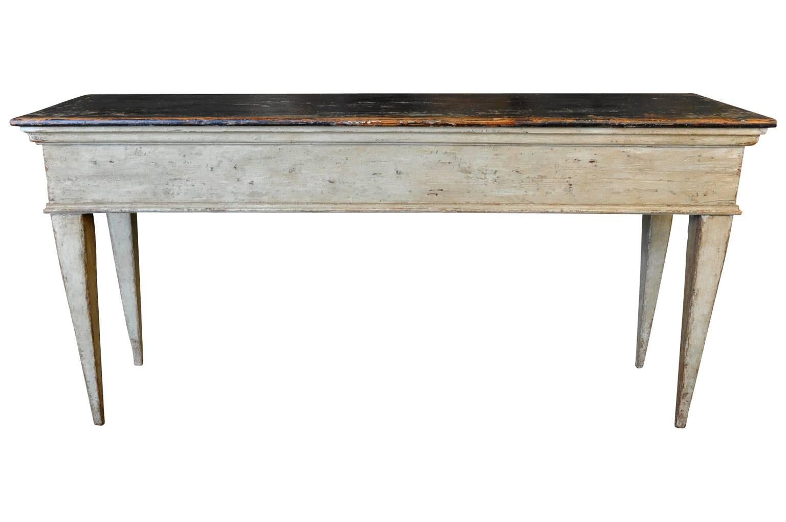 A very striking painted console from Spain. This console is beautifully constructed from 19th century elements and has a wonderful painted finish - terrific patina and texture - in hues a soft sage with an almost black top surface. An excellent
