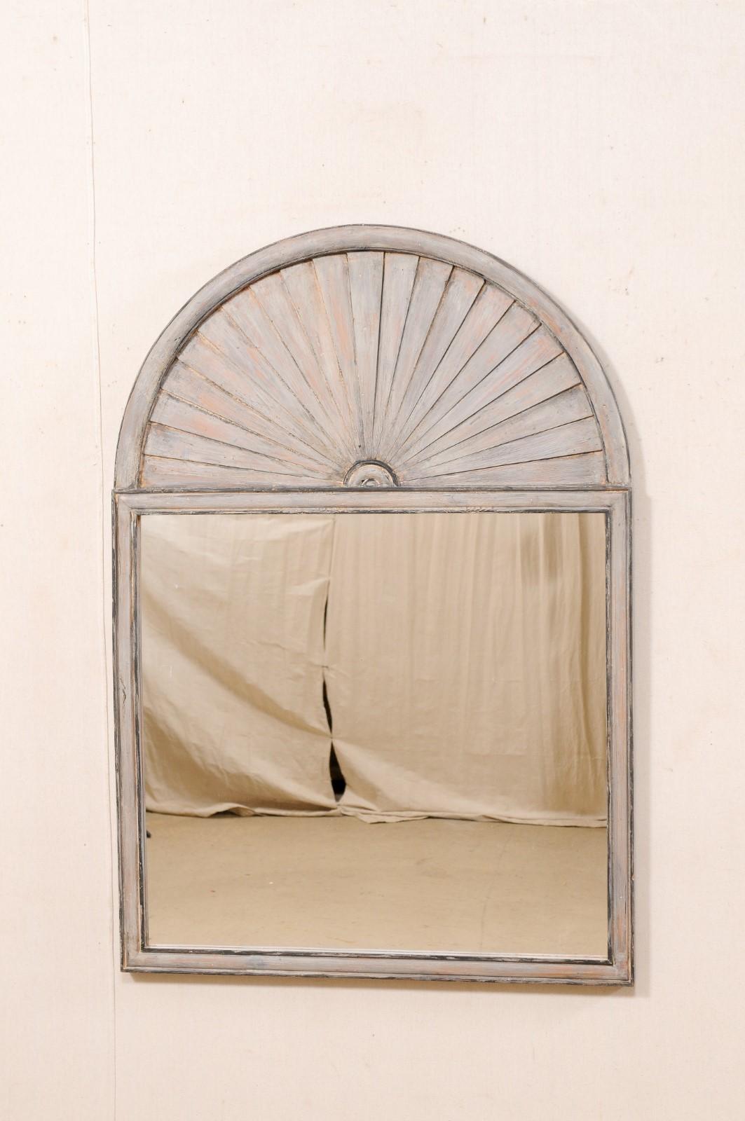 A vintage Spanish carved and painted wood mirror, just over 4.5 feet tall. This wall mirror from Spain features an arch-shaped crest at top which has a nicely textured fan (or perhaps it could be interpreted as a horizon) appearance within a molded