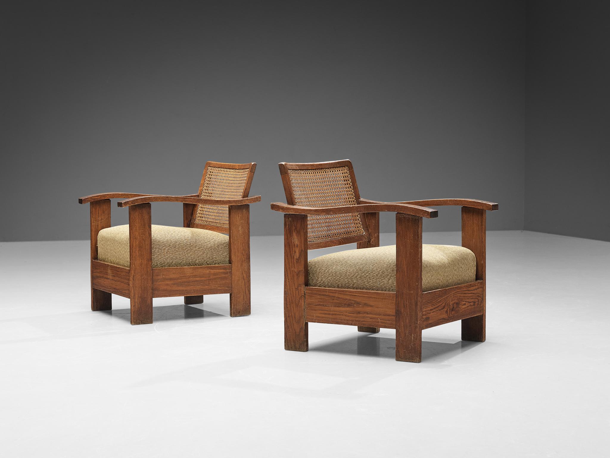 Easy chairs, oak, wicker, fabric, Spain, 1930s. 

Sturdy pair of Spanish easy chairs designed in the 1930s. The structure of these chairs is composed entirely out of oak, while the backrest is made of wicker and therefore creates an open design. Due