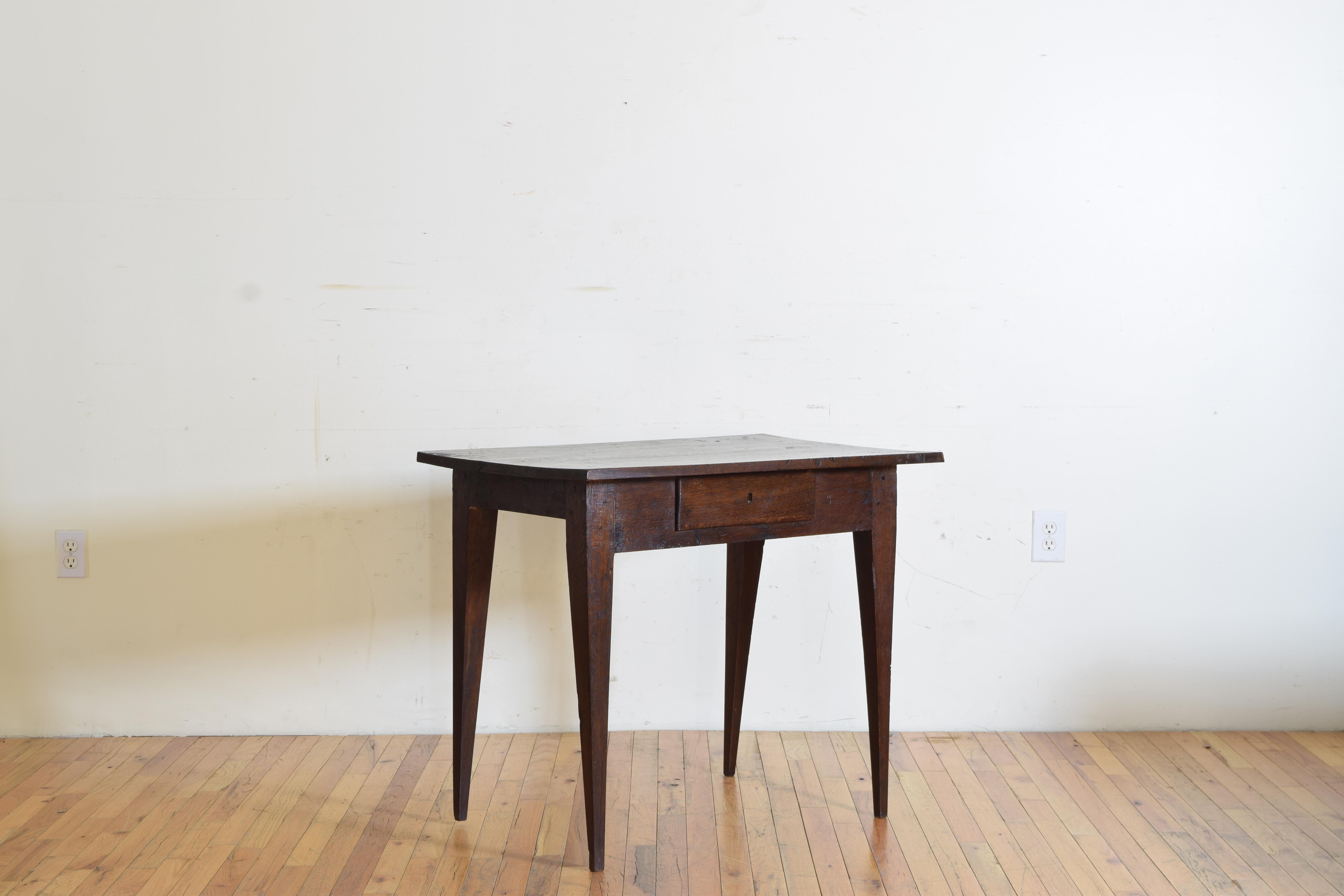 From Pamplona Spain this table has had a large life with a number of cuts and marks to the top, likely a work or kitchen table, the rectangular top above a case housing one-drawer, raised on square tapering legs.