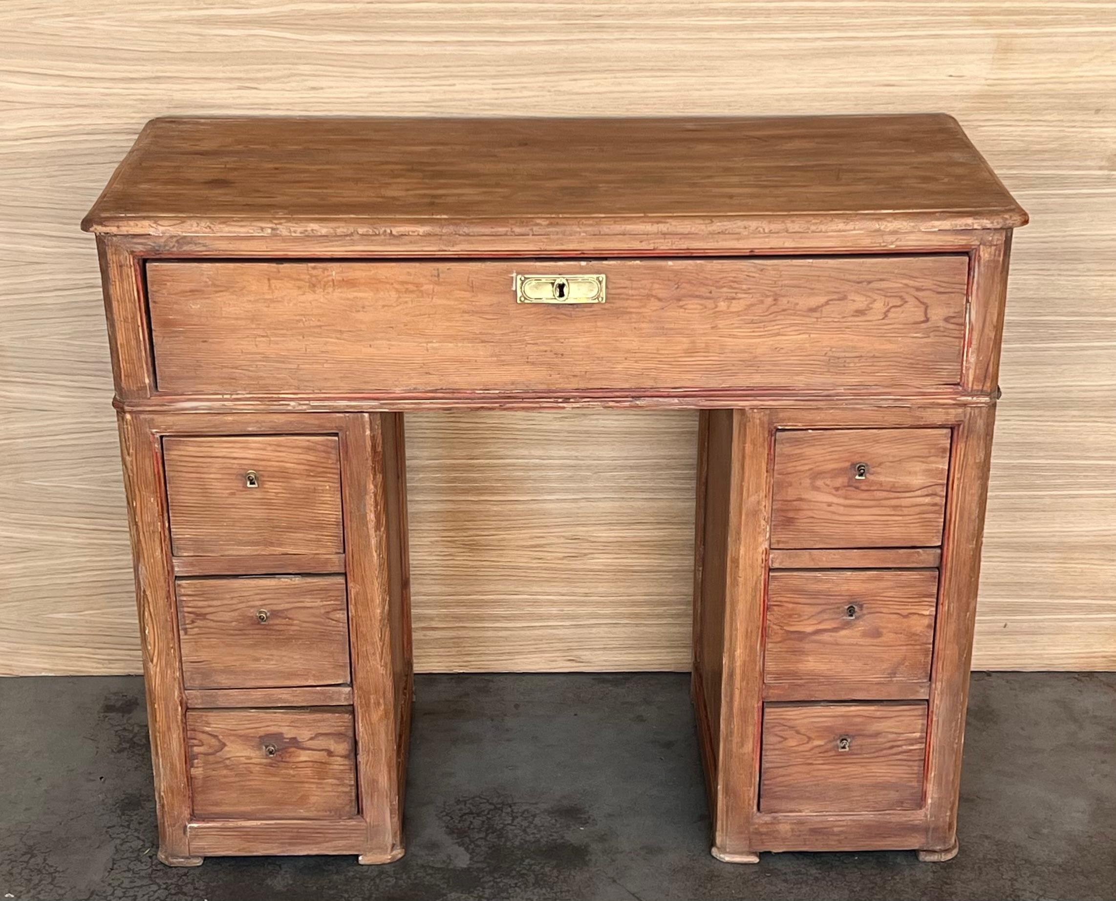 Circa 1890 Spanish Pine Campaign Desk with inset brass pulls  constructed in three sections - the top section with three drawers; each of the double pedestal base sections with three drawers.

The measure from the floor from the bottom drawer is