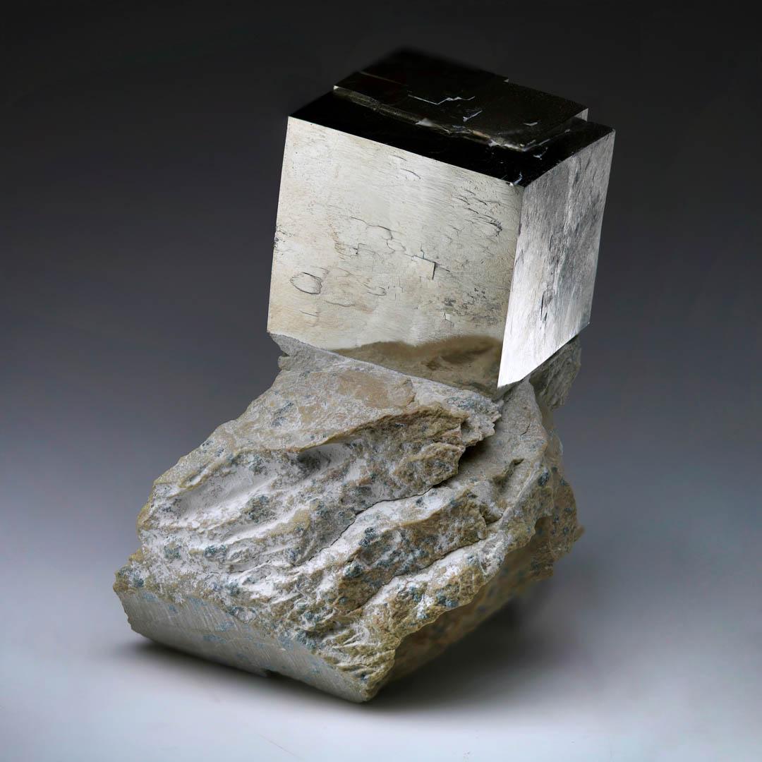 Questo sorprendente esemplare proveniente da Navajún, in Spagna, presenta un grande cubo di pirite con una struttura cristallina incredibilmente unica. Questo raro fenomeno completamente naturale si sviluppa da una matrice di basalto indipendente e