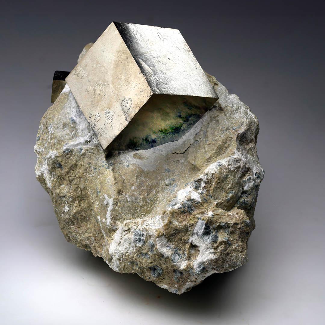 Questo sorprendente esemplare proveniente da Navajún, in Spagna, presenta due cubi di pirite completamente naturali che spuntano da una matrice di basalto. Il cubo più grande misura 1,5
