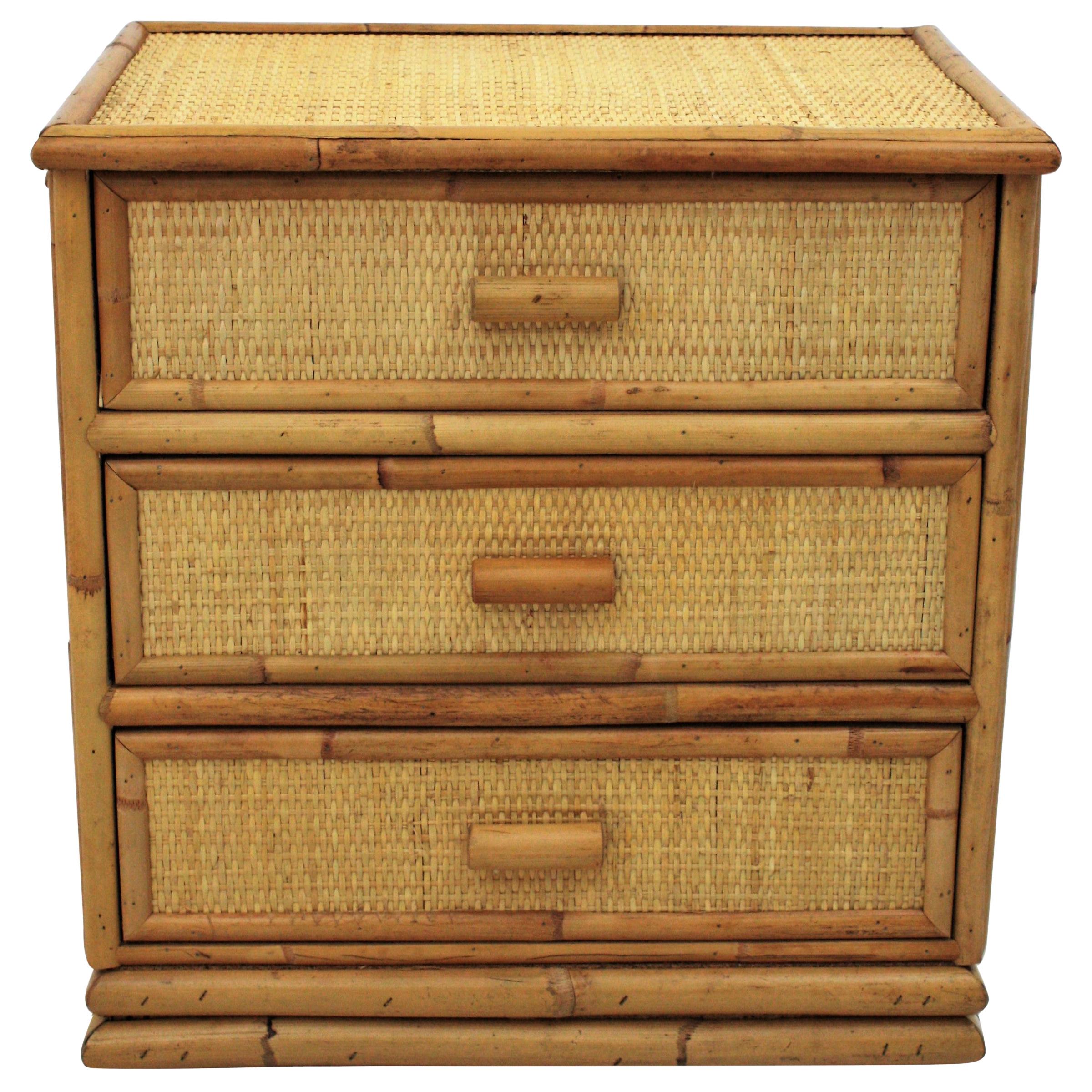 Lovely rattan and bamboo small chest, end table or nightstand, Spain, 1970s.
This small chest of drawers has a wood and bamboo construction. The top, sides and the front part of the drawers are upholstered with woven rattan / wicker. It has bamboo