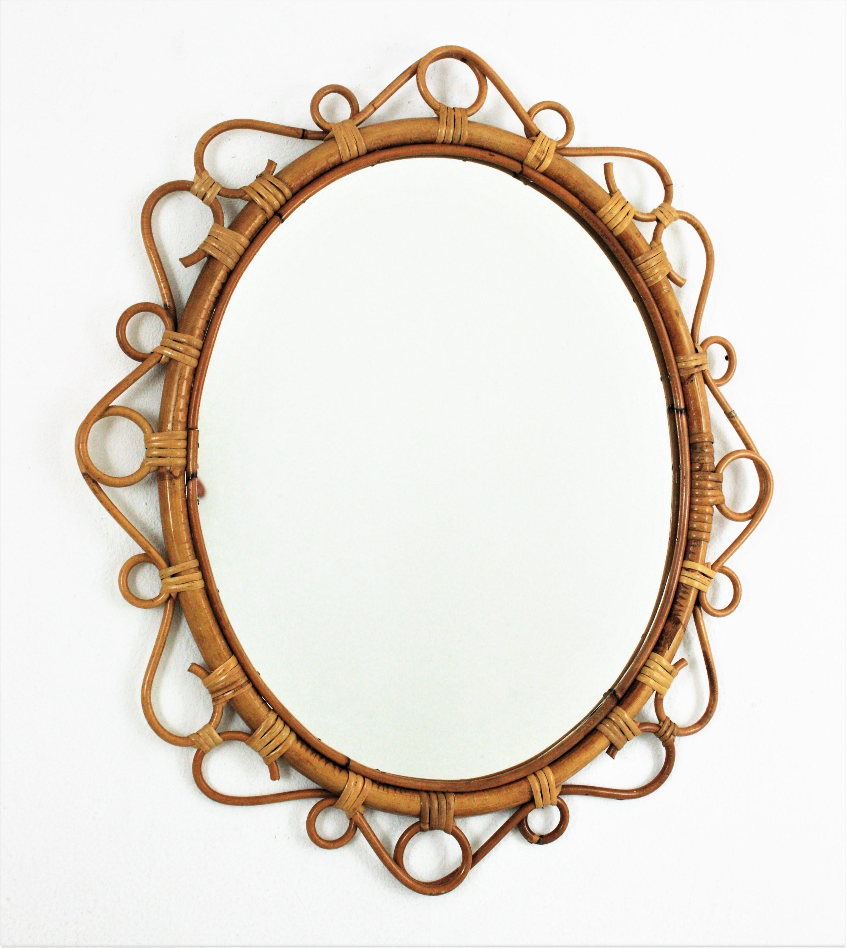 Eye-catching handcrafted bamboo and rattan oval mirror with scroll detailing surrounding the frame. Spain, circa 1960s.
This Mediterranean wall mirror features an oval bamboo frame surrounded by rattan scroll and circle decorations.
It will add a