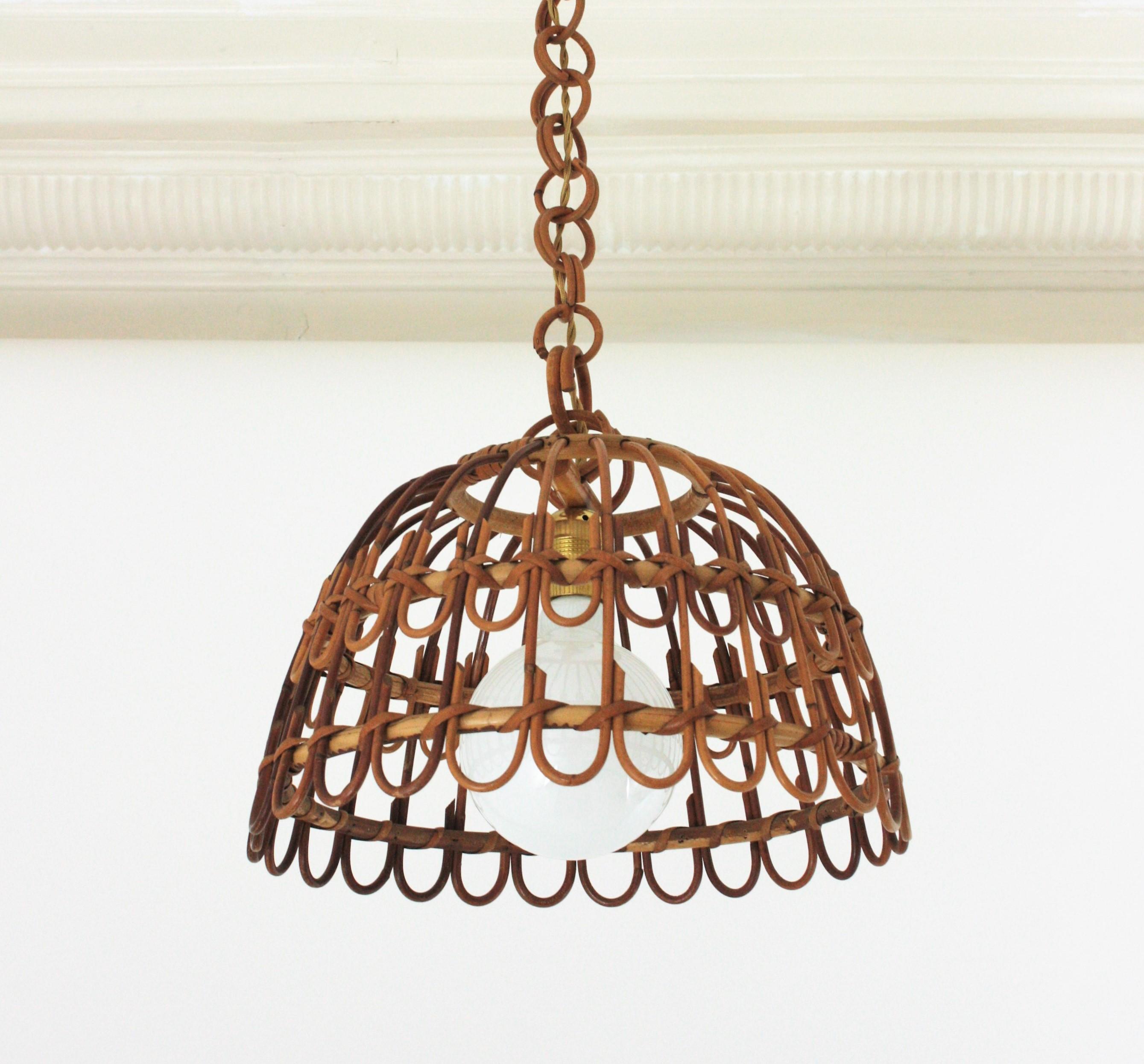 Eyecatching handcrafted rattan pendant light with geometric petal design. Spain, 1960s. 
This suspension lamp has a bell shaped lampshade hanging from a rattan / bamboo chain topped by a wicker wrapped canopy. The length of the chain can be