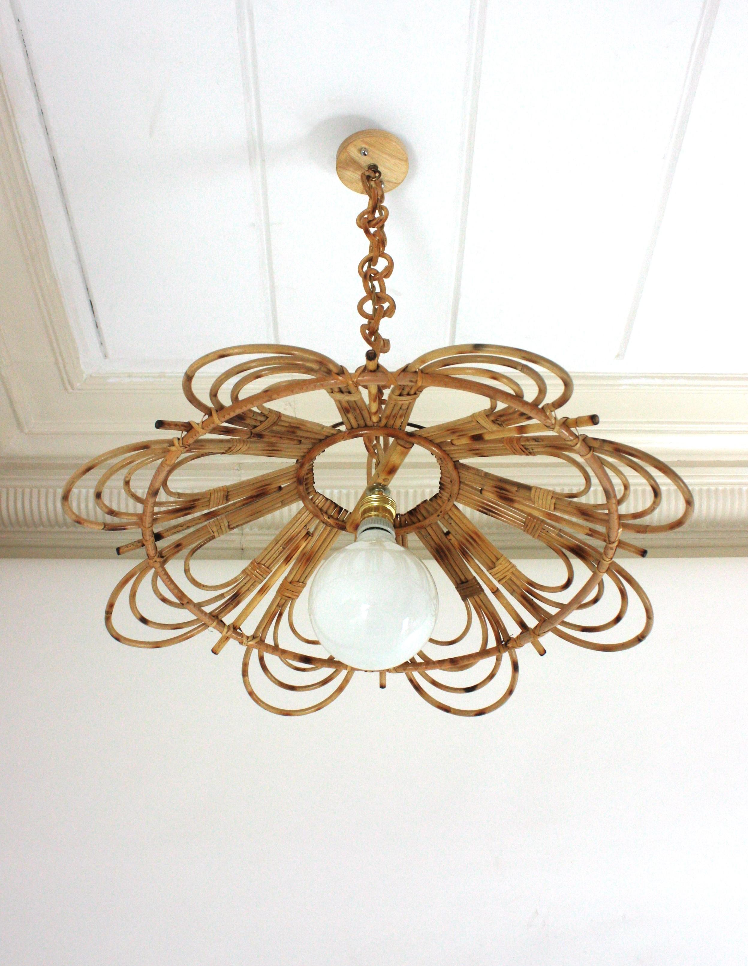 Flower Shaped Rattan Ceiling Pendant, Large Size. Spain, 1960s
This large pendant has an eye-catching flower design featuring 4 layered rattan petals joining between them as a flower.
It hangs from a chain with round rattan links ended by a wooden