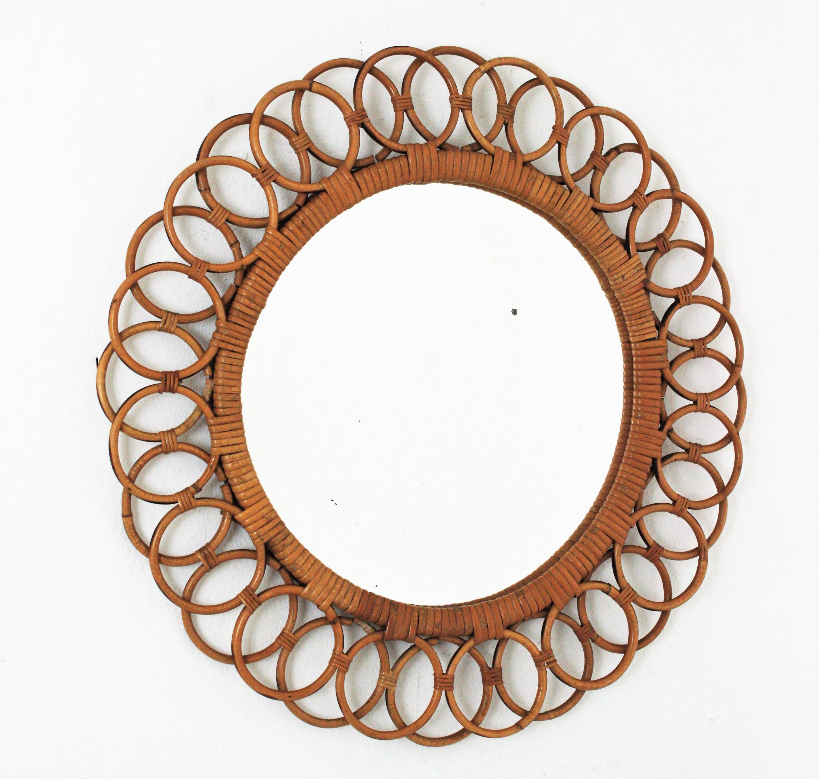 Midcentury Round Wall Mirror, Rattan, Wicker, Spain, 1960s
Eye-catching rattan round mirror framed by rattan rings or circles linked between them. The central ring surrounding the glass is wrapped by wicker cane tape
This mirror has all the taste