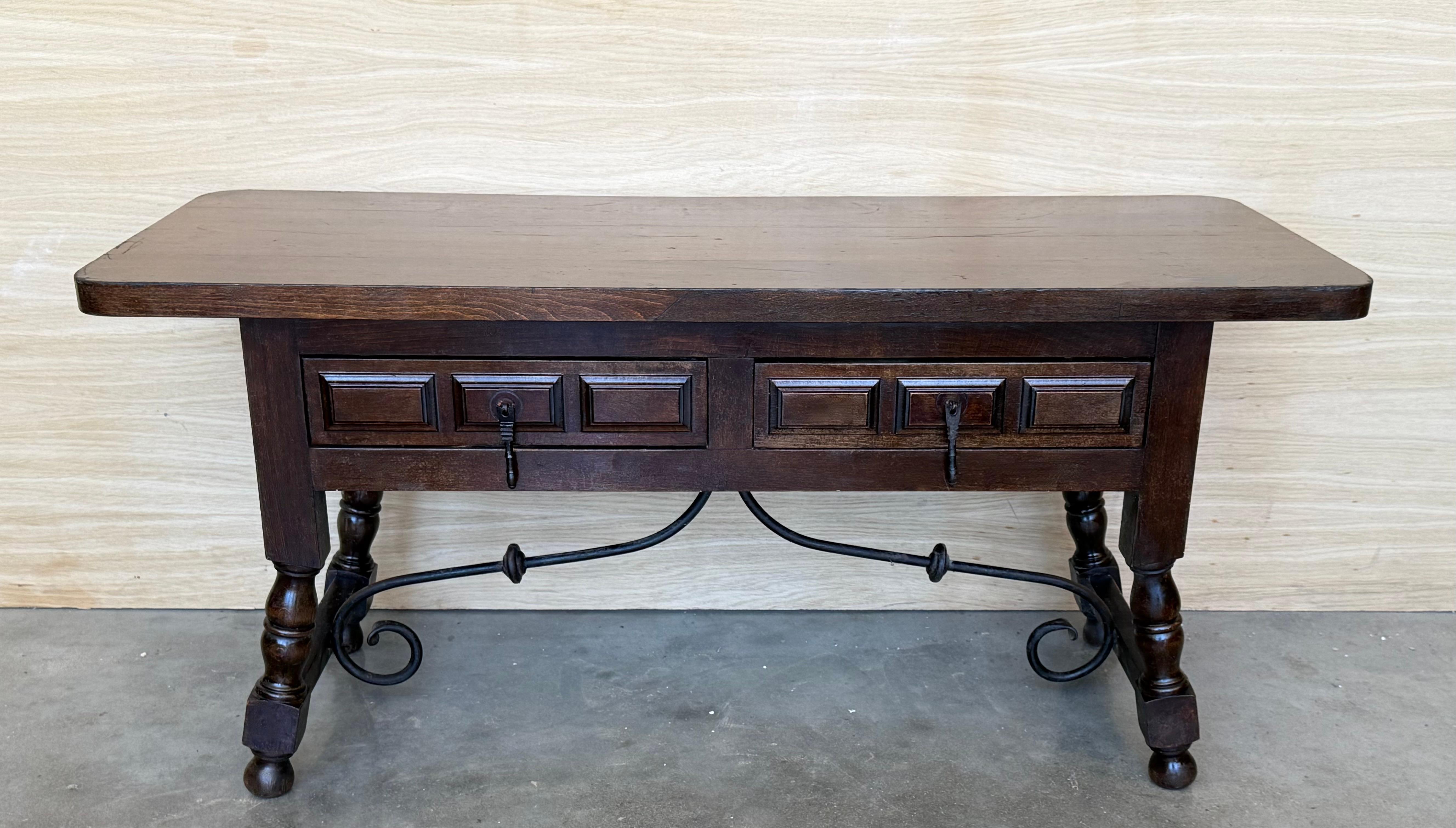 Table basse rectangulaire espagnole avec pieds tournés et traverse en fer.
Cette table possède deux tiroirs fonctionnels de chaque côté, parfaits pour une table de canapé.