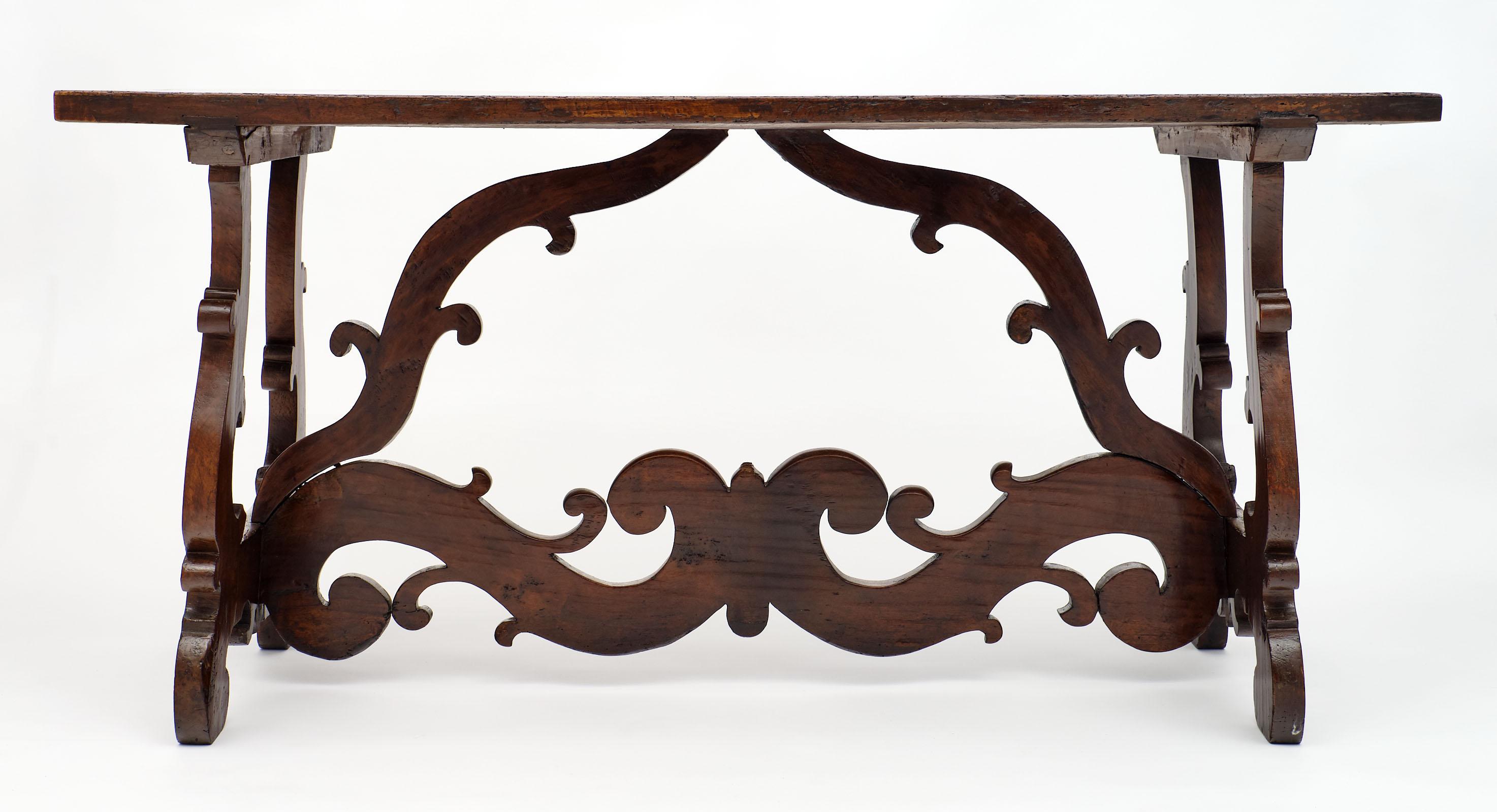 Solid walnut antique Spanish Renaissance “Lyra” Trestle table, finely hand carved base featuring two Lyra pedestals connected with an ornately hand carved stretcher. It is finished with a beautiful and lustrous natural wax.