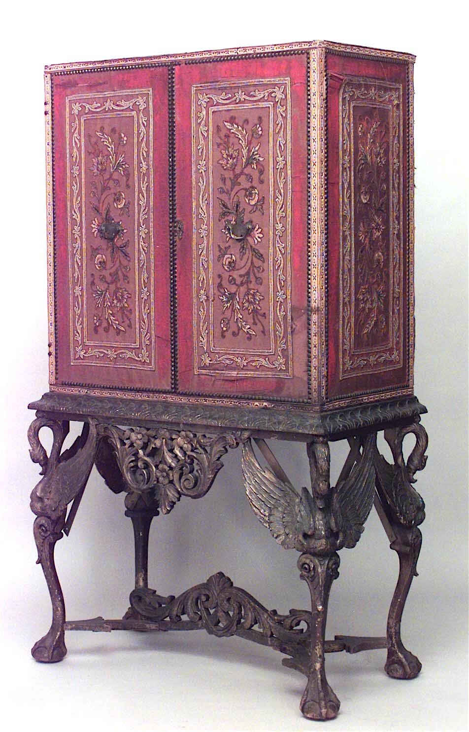 Spanish Renaissance style (19/20th Century) cabinet on stand with a Pair of gold thread embroidered red silk upholstered doors on a giltwood base with swan monopodia legs.

