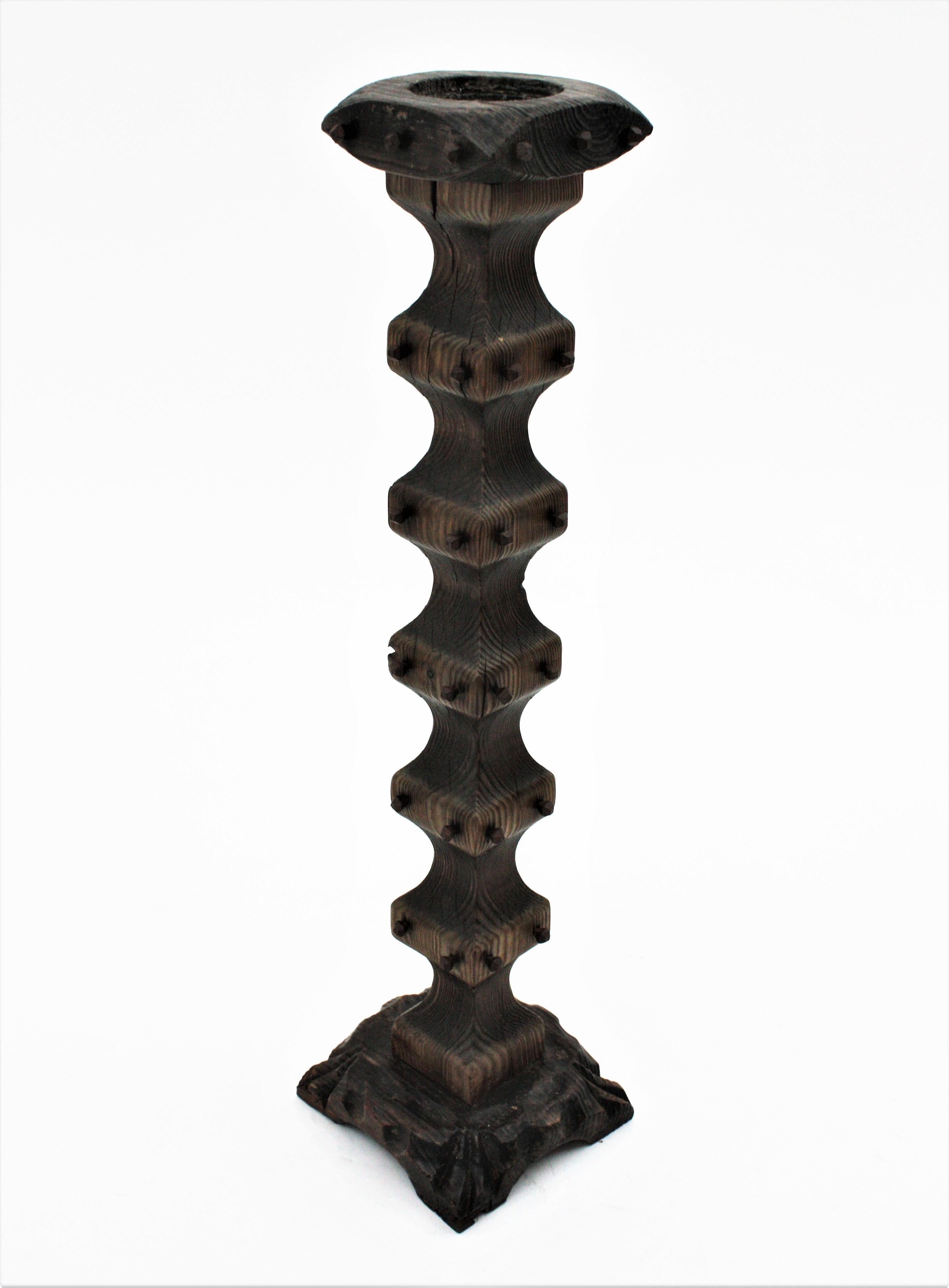 Floor standing candle holder in turned wood and iron nails, Spain, 1940s.
Eye-catching floor candle holder in pine wood. It has squared shape, scalloped turned design and wrought iron nails decorative details 
Terrific aged patina.
This piece has a