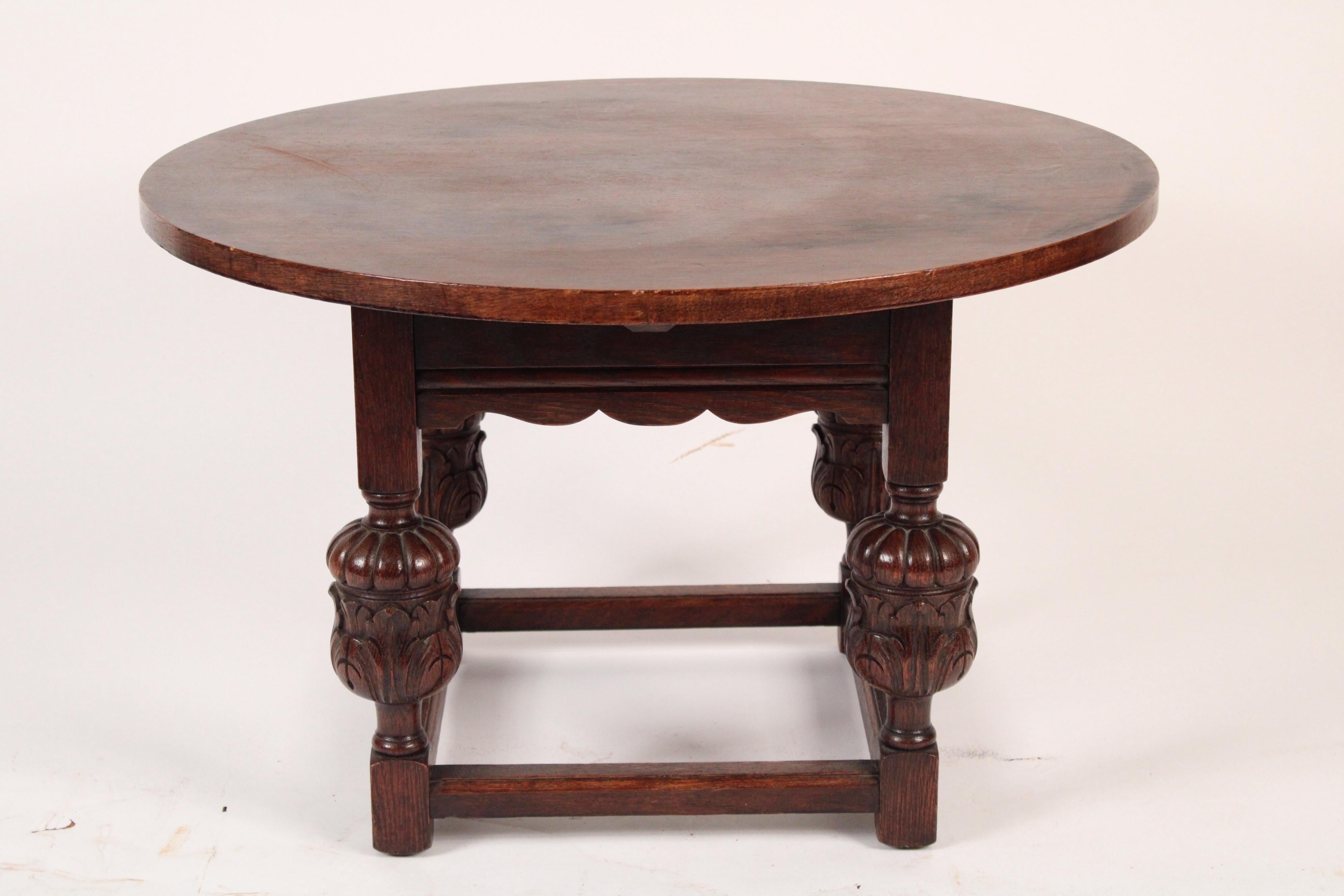 Spanish revival round oak coffee table, circa 1930. With a round top and four bulbous carved oak legs.