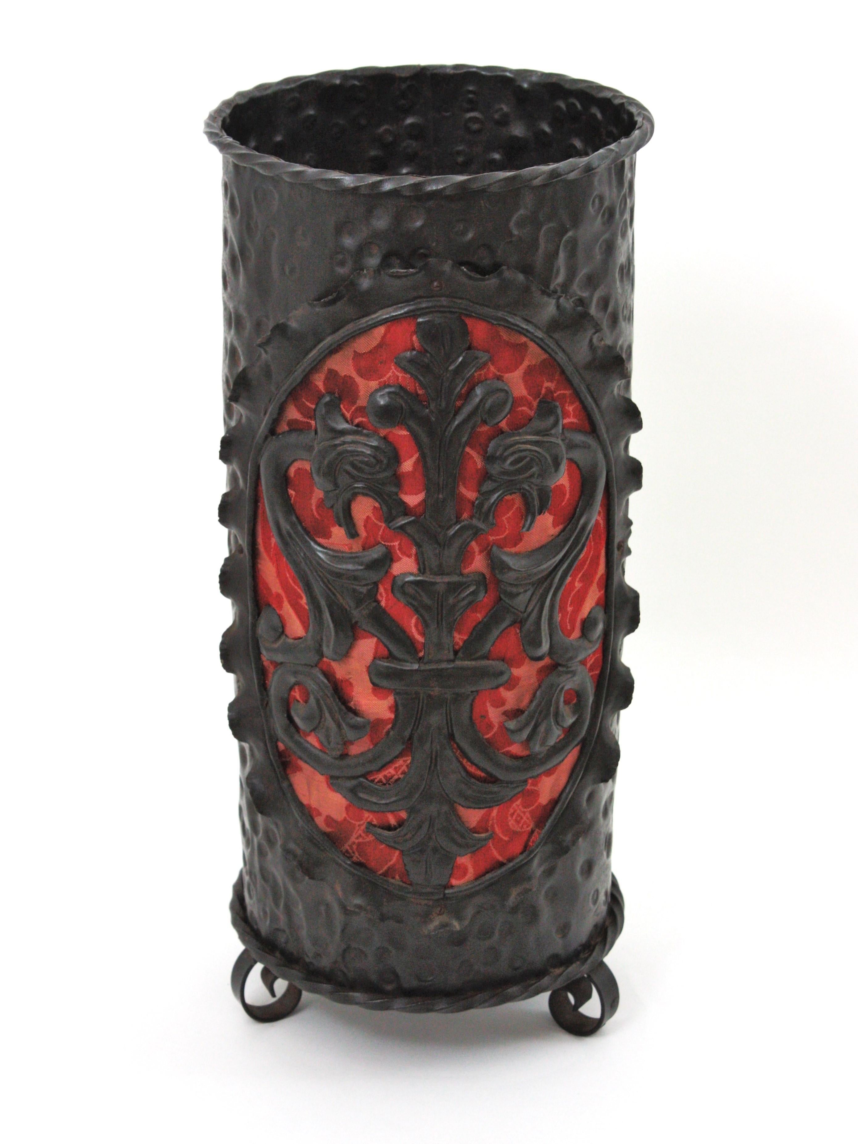 Paragüero del Renacimiento en hierro forjado, España, años 40.
Impresionante paragüero con decoración de escudo de armas con detalles de dragón y detalle de tejido de damasco jacquard rojo. 
Este paragüero o soporte para plantas fue fabricado a mano