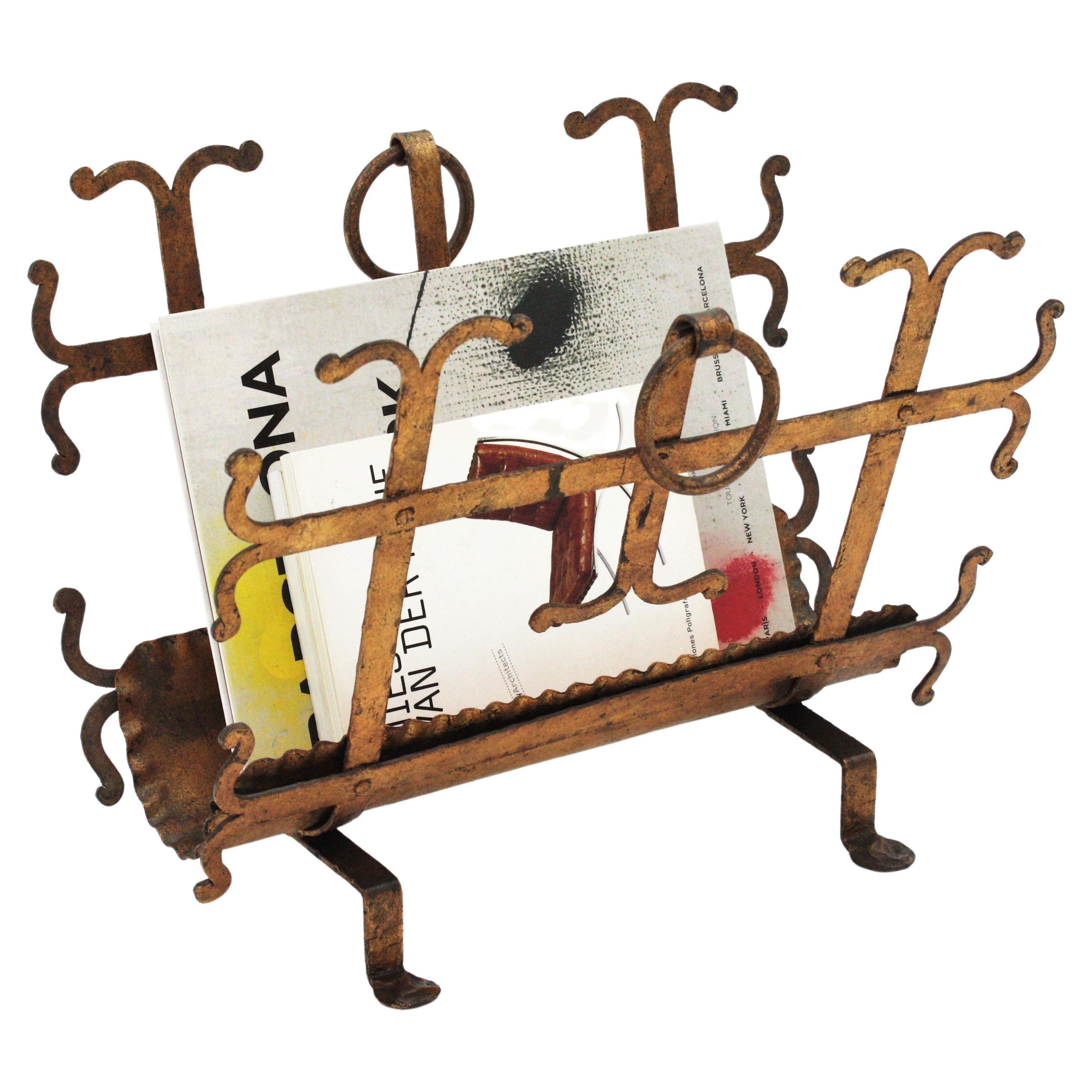 Spanish Revival magazine rack, wrought iron, gold leaf, Spain, 1940s-1950s.
Wrought iron magazine rack with gold leaf finish and Gothic accents.
This hand-hammered magazine or newspapers rack has scrolled details and ring handles at both sides.