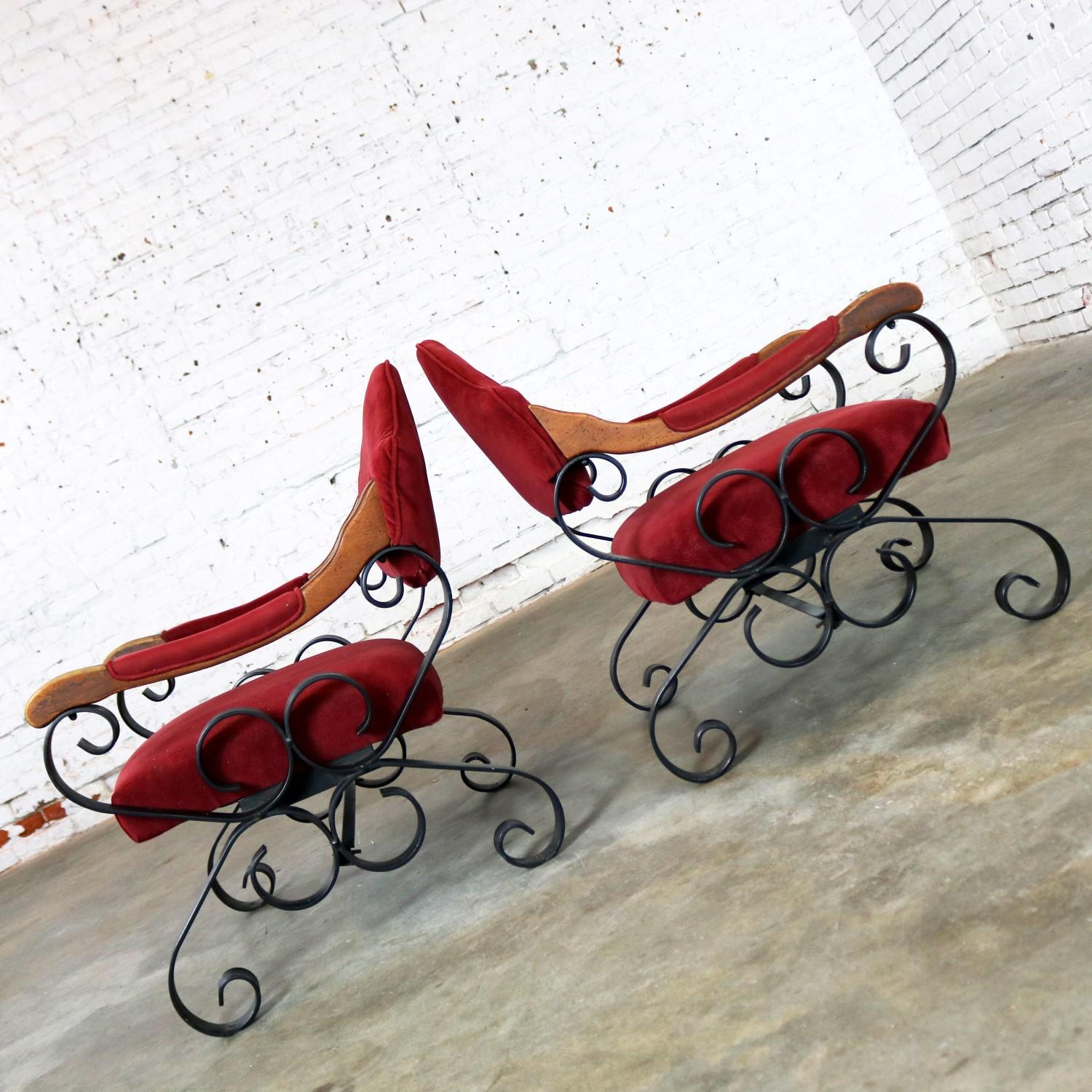 Fabulous pair of Spanish Revival Mediterranean style wrought iron, wood, and upholstered lounge chairs after Artes De Mexico Internacionales SA. They are in wonderful vintage condition. The wood has a nice age patina, the black scrolly ironwork