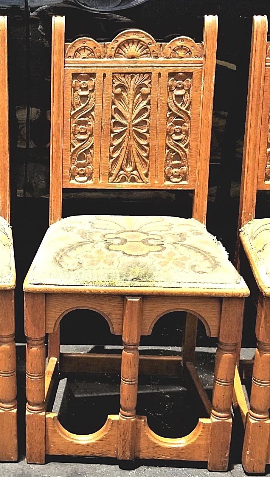 Set of (4) Antique hand carved wood oak Jacobean Spanish Revival Mission Style Dining Chairs.

Features: All hand carved with unique openings in fronts that act as footrests.

 Approximate Measurements in Inches
37 high at backs
18 1/2 wide at