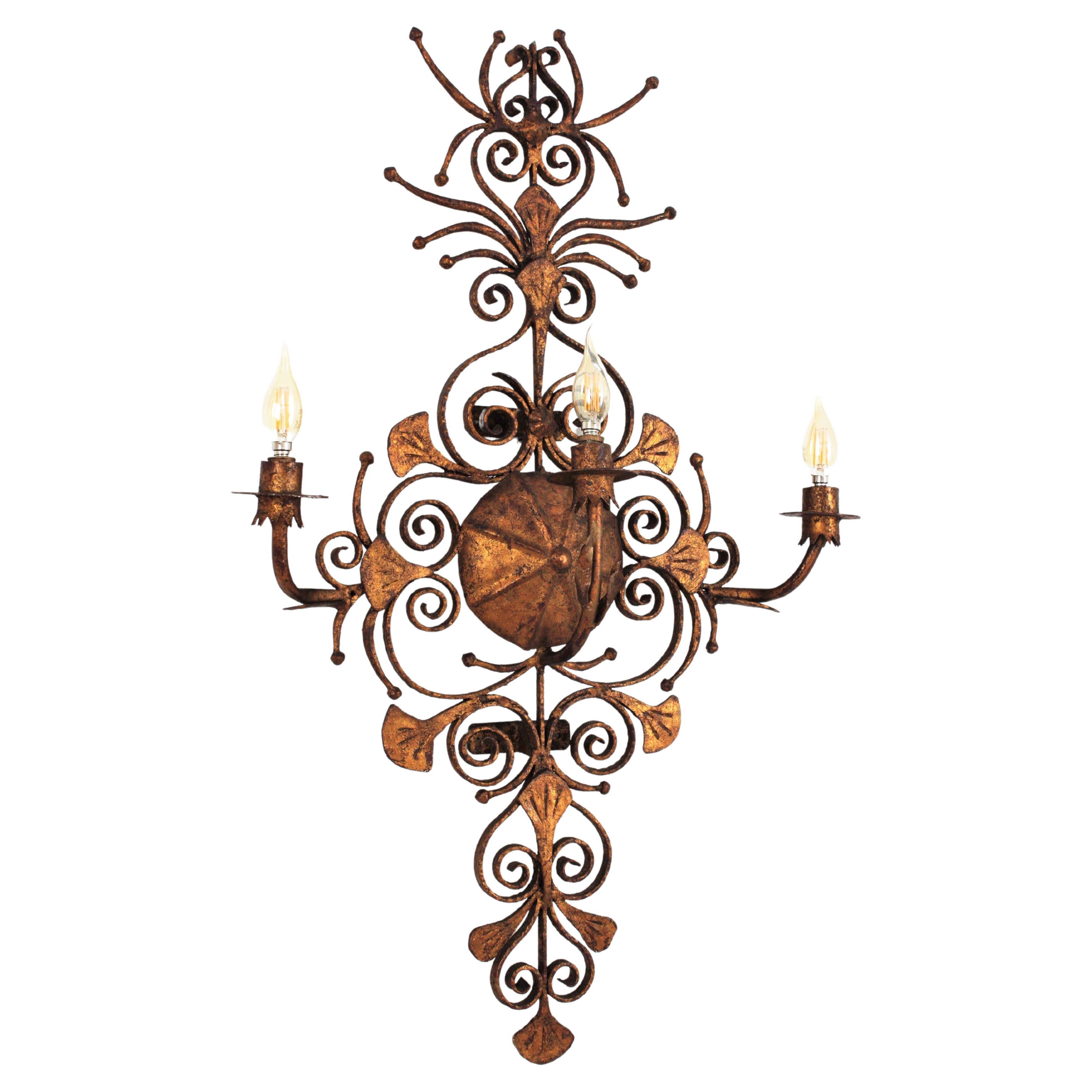 Outstanding Hand Forged Scrollwork three light wall sconce. Spain, 1940s
This monumental wall sconce was handcrafted with an excellent metal work and Gothic / medieval inspiration. The backplate has a heavily detailed iron scrollwork, all made by