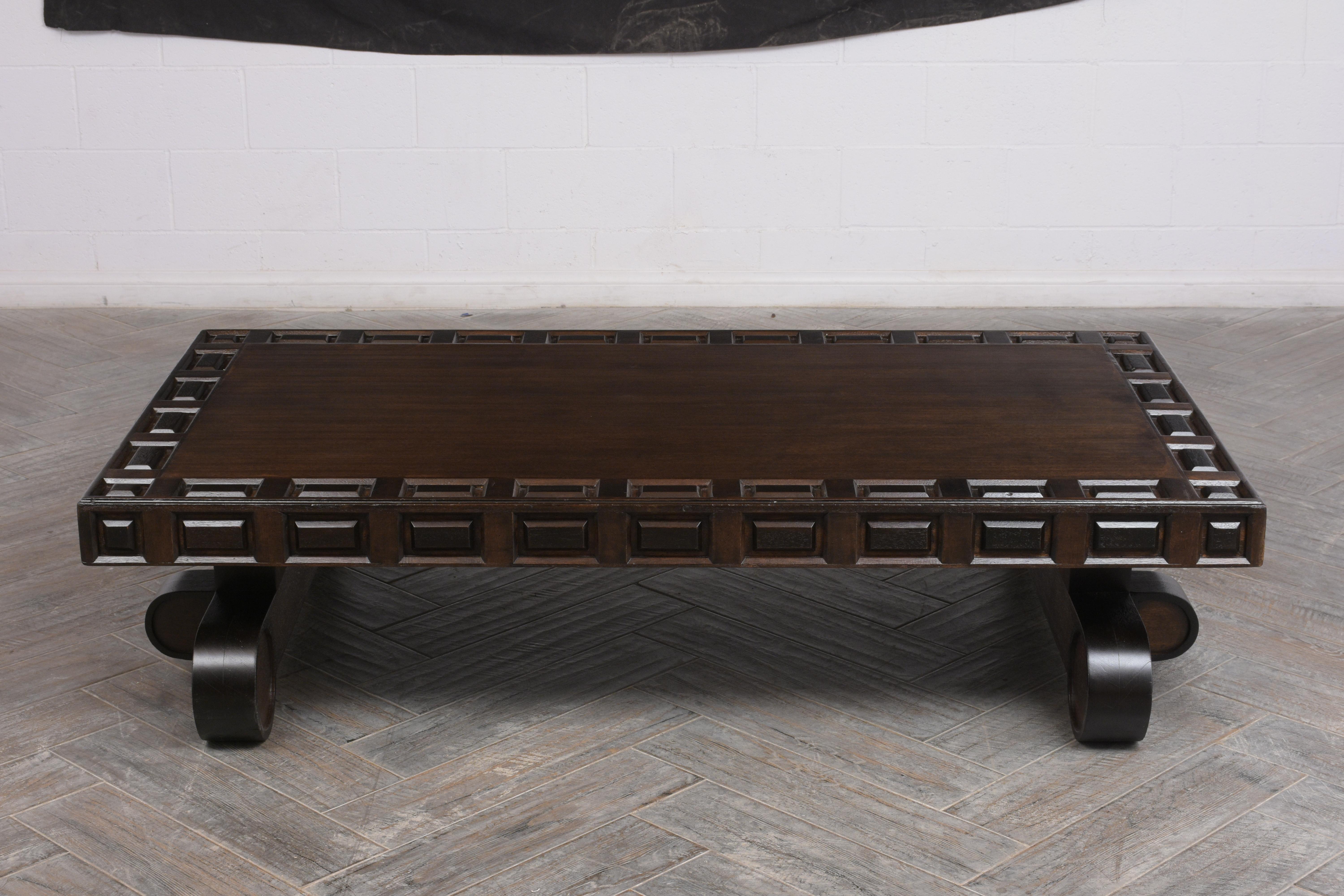 This Spanish Colonial Style Rectangular Low Coffee Table has been newly stained a dark walnut color with a satin lacquered finish. It has a large carved top with molded accents running along the edges, and the top sits on thick stretched rounded