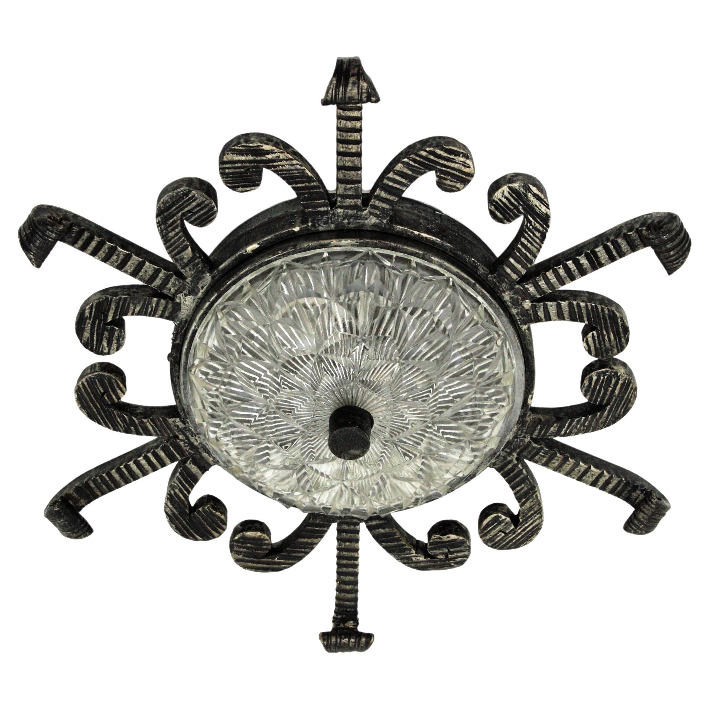 Hermoso aplique de hierro forjado con detalles en volutas y pantalla de cristal prensado, España, años 50.
Esta lámpara forjada a mano tiene un diseño interesante y una construcción muy pesada. El marco tiene detalles de volutas gruesas, diseño de