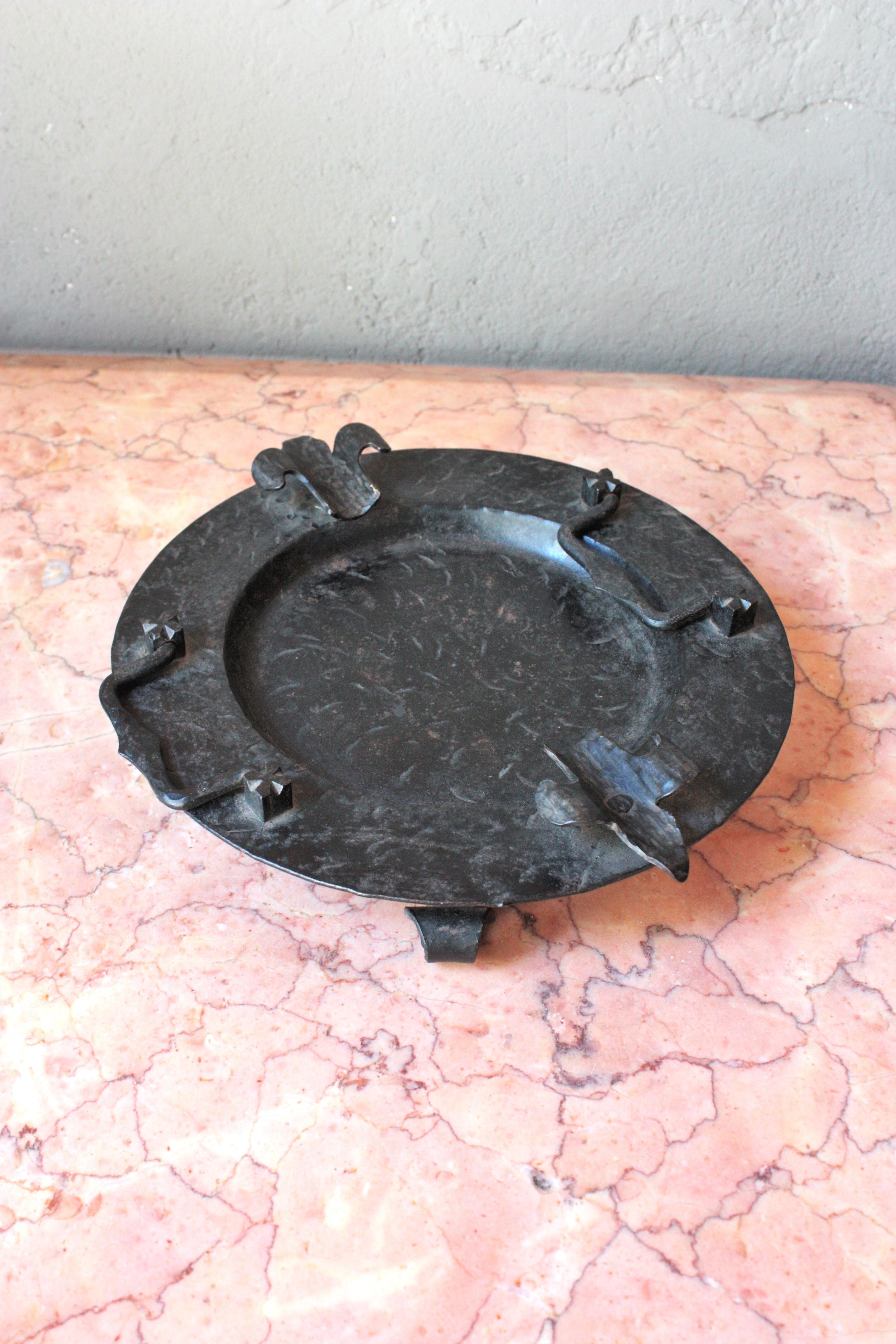 Handgeschmiedeter Aschenbecher aus Eisen / Vide-Poche oder Getränketablett, Spanien, 1930-1940.
Spanischer schmiedeeiserner Aschenbecher mit Griffen.
Dieser handgefertigte Aschenbecher ist durch die Hammerschläge stark verziert. Er steht auf drei