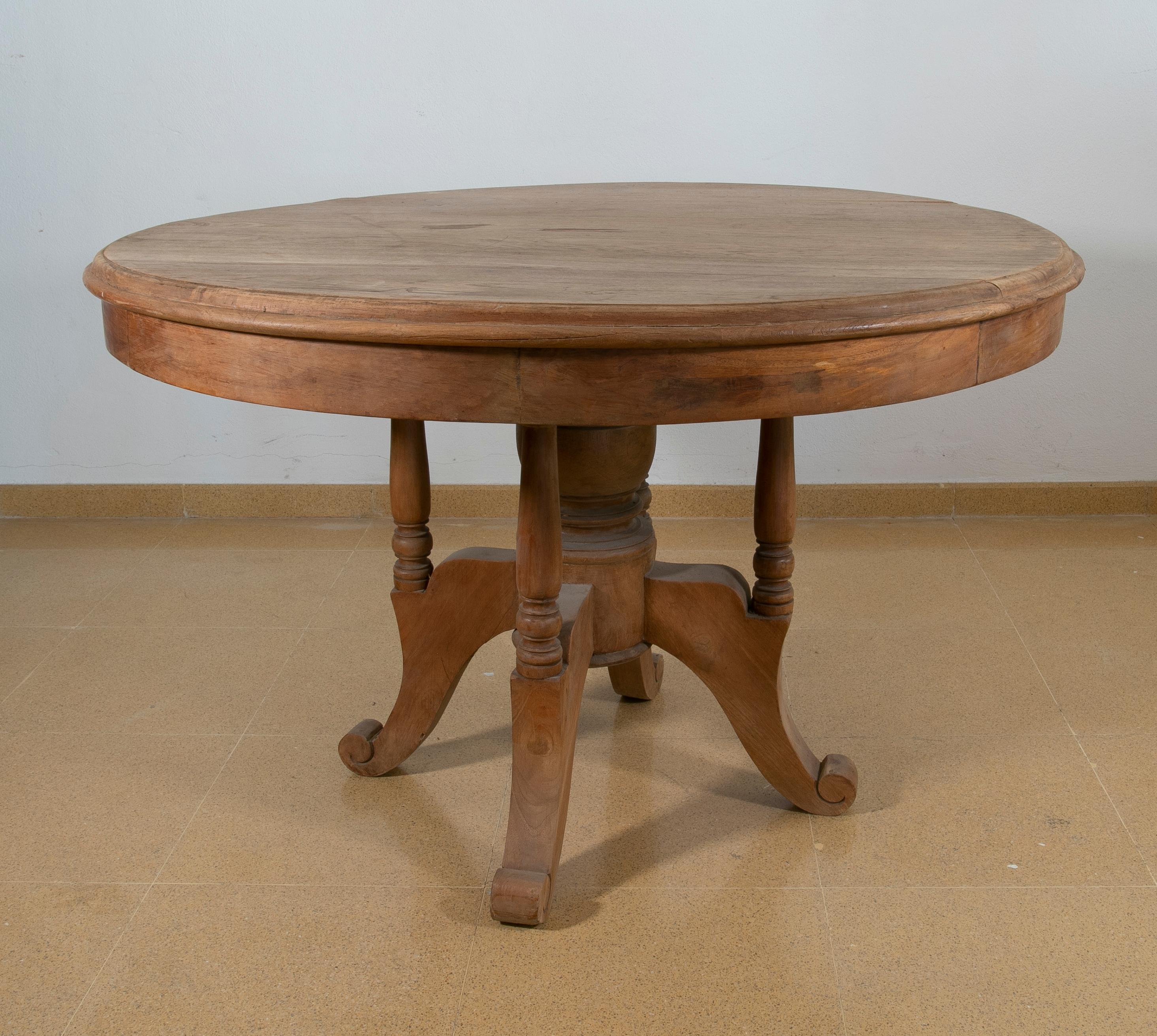 Table ronde espagnole en bois dans la couleur d'origine avec des pieds tournés.