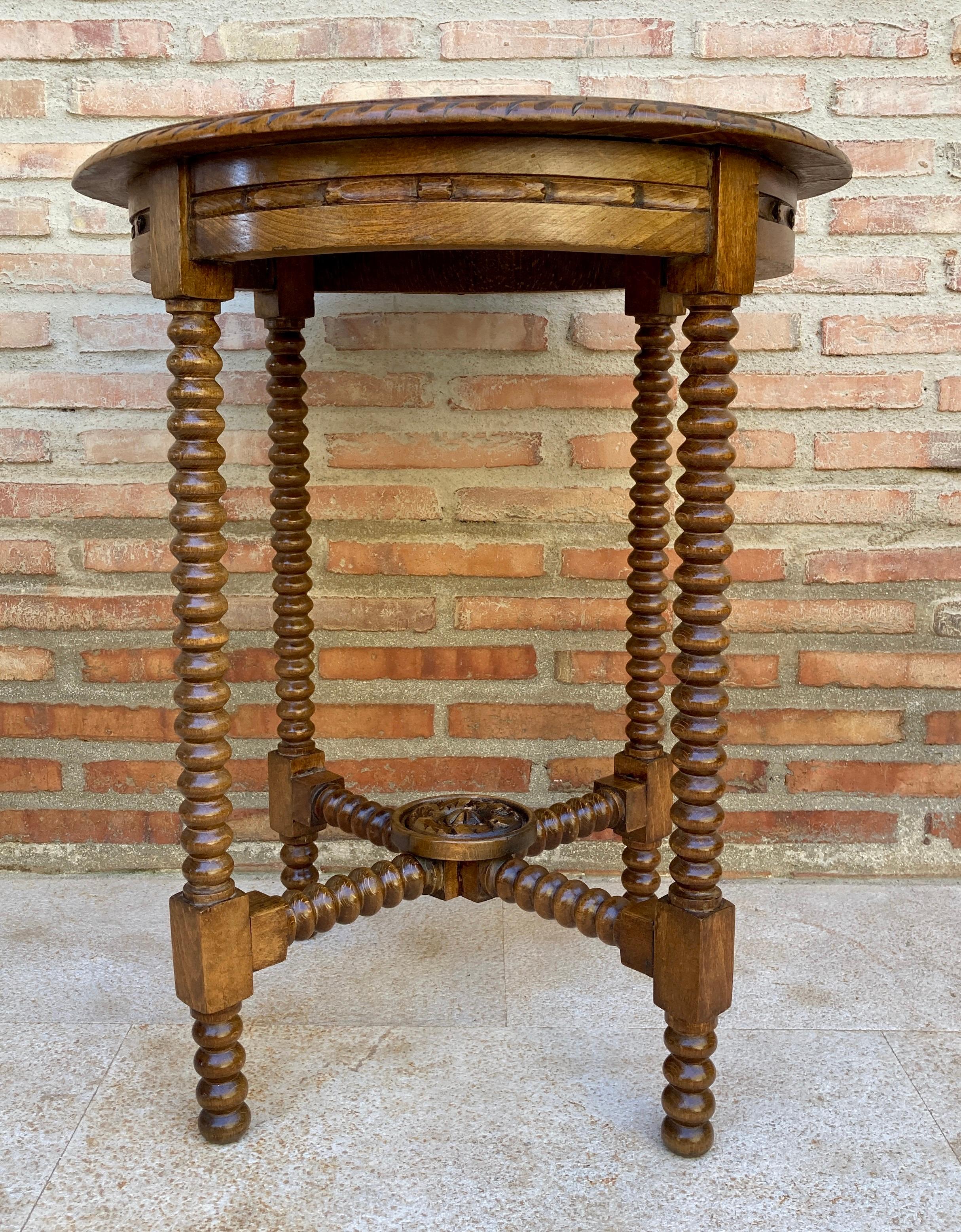 20th century Spanish walnut side table, with carved apron and fluted legs. Created in Spain during the first decade of the 20th century, this walnut side table features a round top, sitting on an apron carved on all sides. The table rests on four