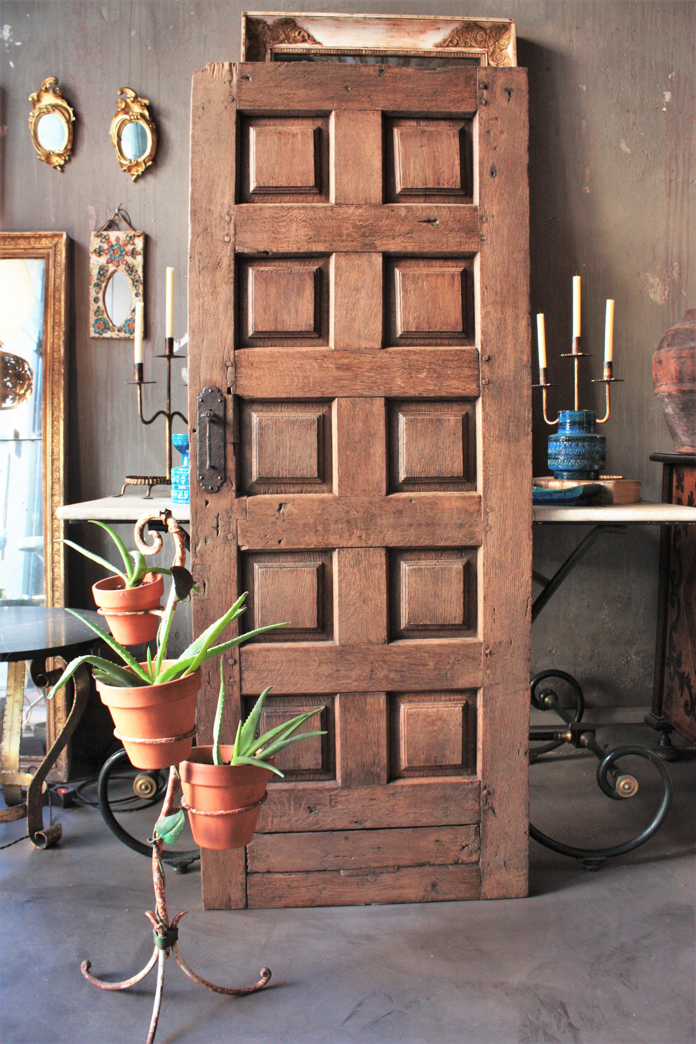 18th century Spanish solid oak antique rustic door with carved panels and hang forged iron pull adorned with a scallop shell. 
This door comes from Galicia, the Northern part of Spain.
The handle is adorned by the an iron scallop shell, this shell