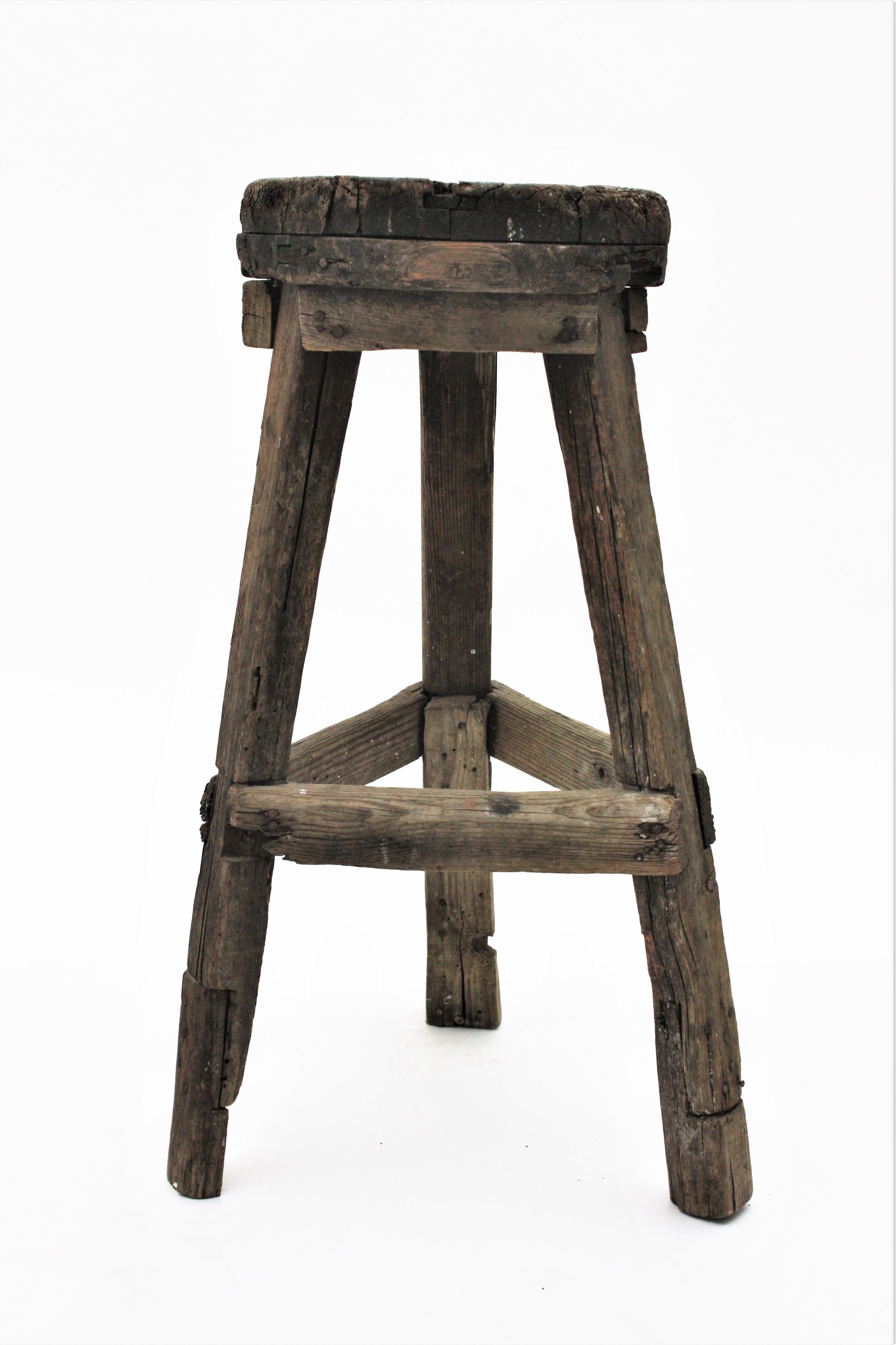 Rustic wooden high stool with a three-legged base and round seat. Spain, 1920s-1930s.
From the northern part of Spain this rustic stool has a primitive construction, great shape and character.
This traditional farm or workshop rustic stool has a