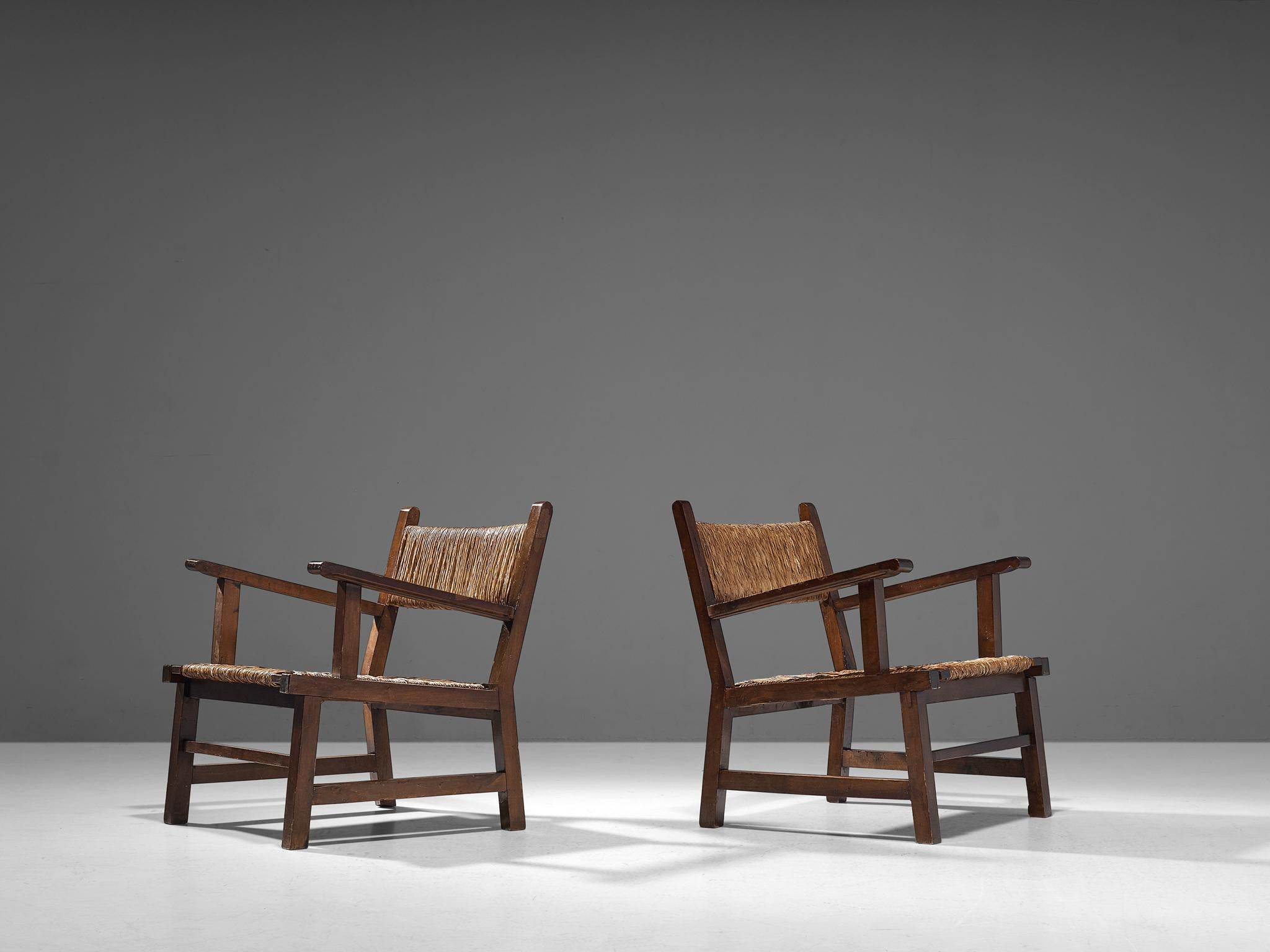 Pair of armchairs, stained wood, straw, Spain, 1950s

These beautifully constructed armchairs conceal an evolved rustic character with great quality of elegance. The wooden frame features a solid construction of straight lines and round corners.