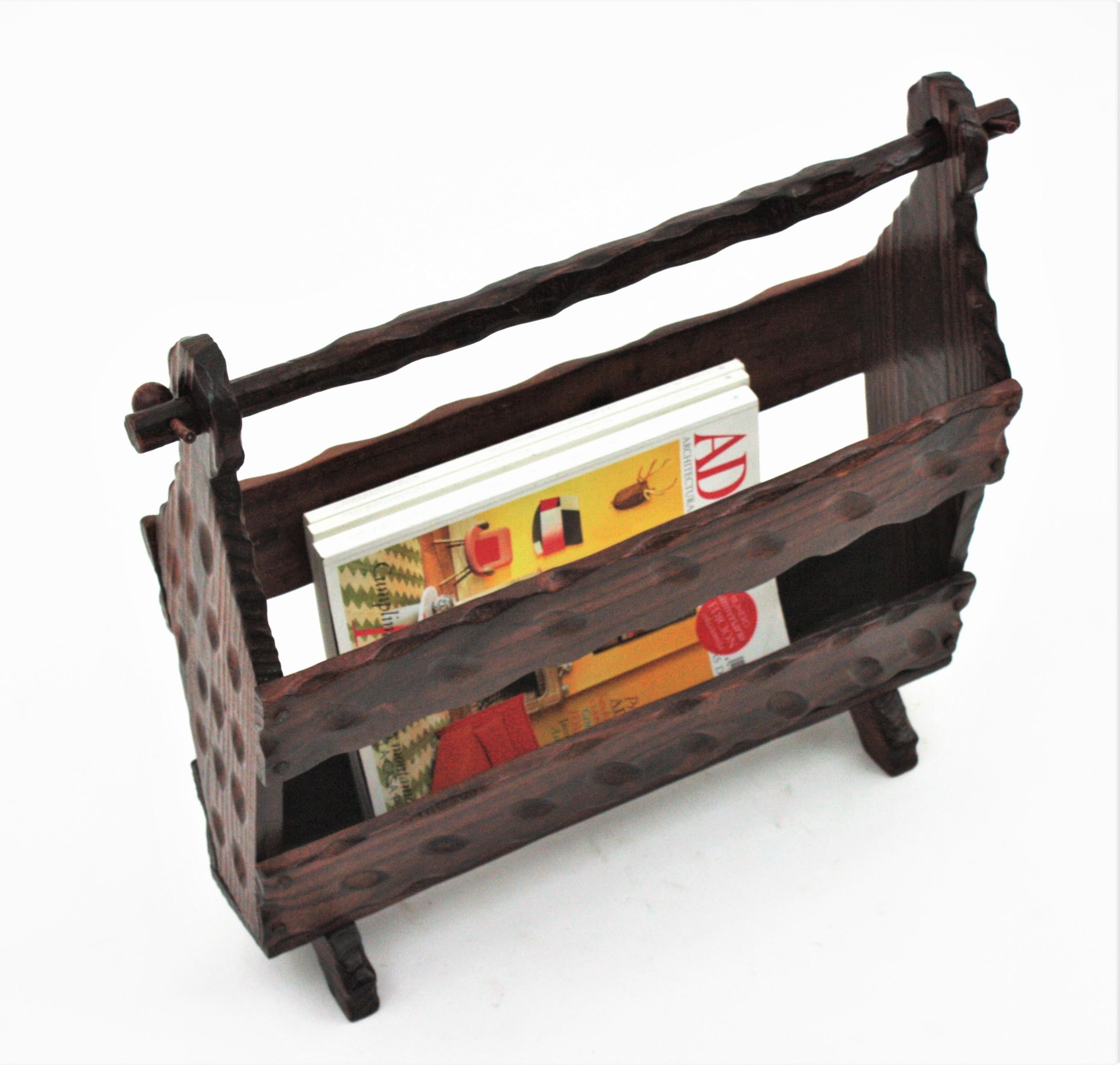 Handcarved pine wood magazine rack  Spain, 1940s.
It has scalloped details on the handle, beautiful carvings thorough and iron nails accents.
It  has a rustic finish and spanish colonial accents.
It will be a nice a addition near the sofa in a