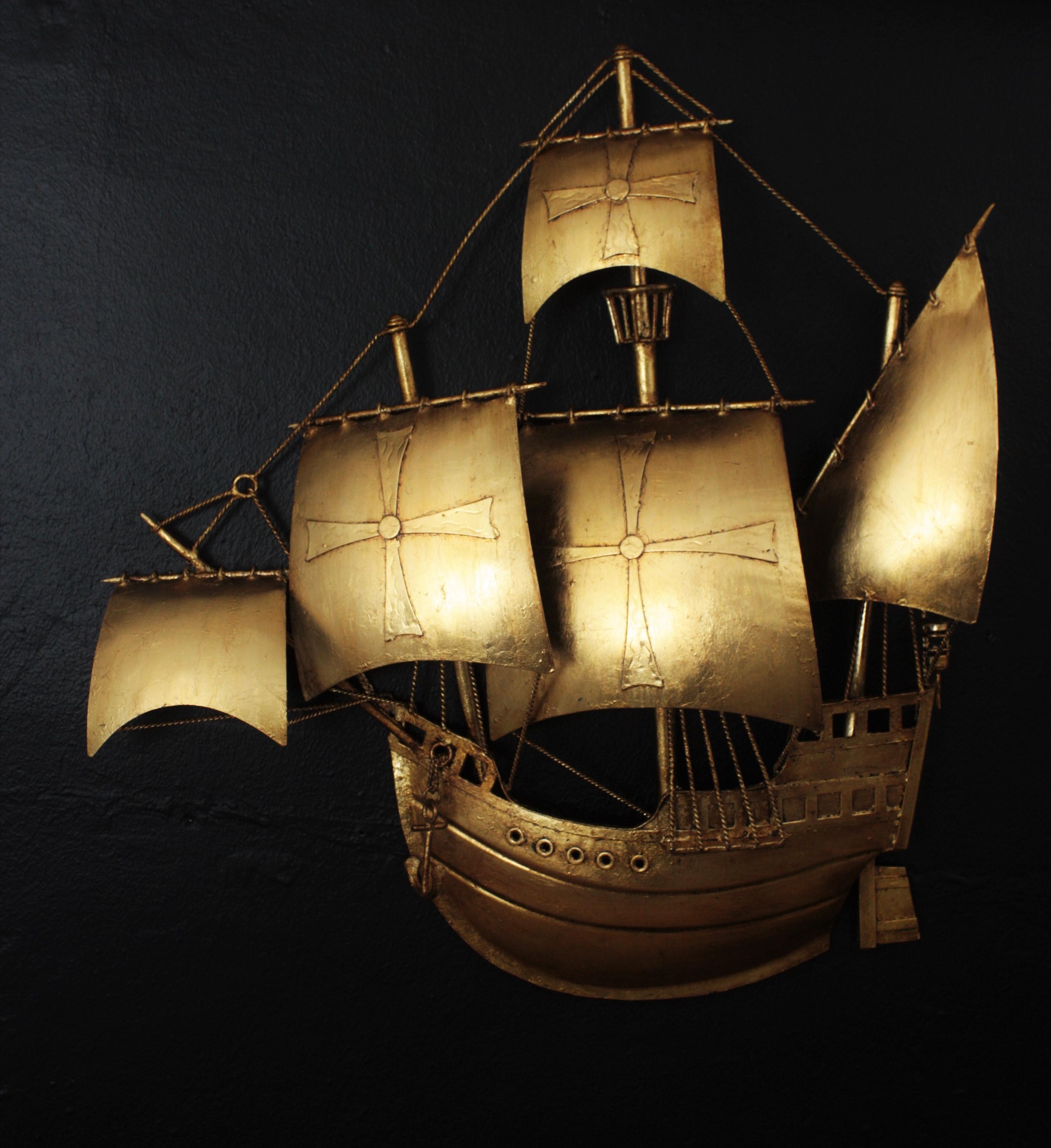 Spanish galleon or sailing ship wall sconce, gilt iron. Spain, 1950s
In the style of Gilbert Poillerat.
This spanish galleon wall light was handcrafted in Spain at the mid-20th century period representing the Santa Maria, the flagship of the three